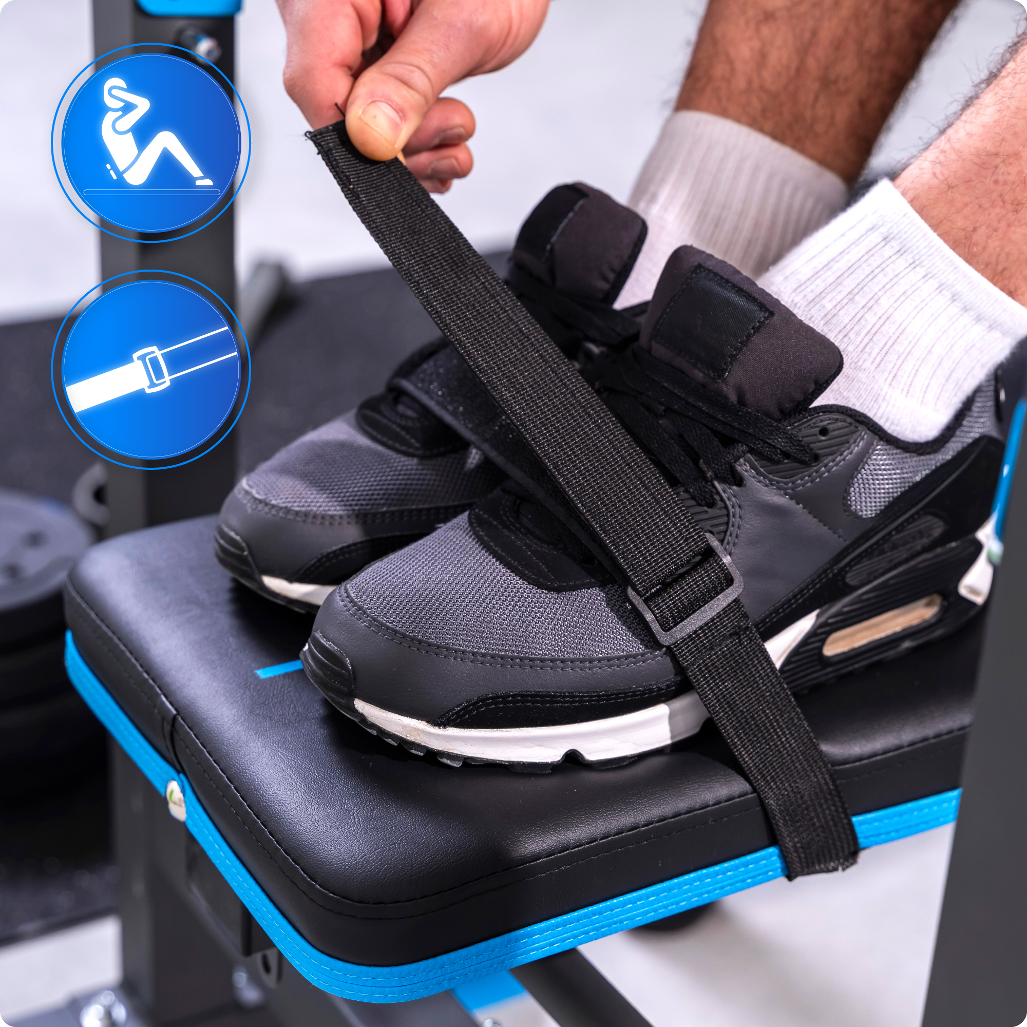 Zbliżenie stóp z butami i paskiem na ławce do ćwiczeń. Ławka jest czarna i niebieska. Ikony w rogu.