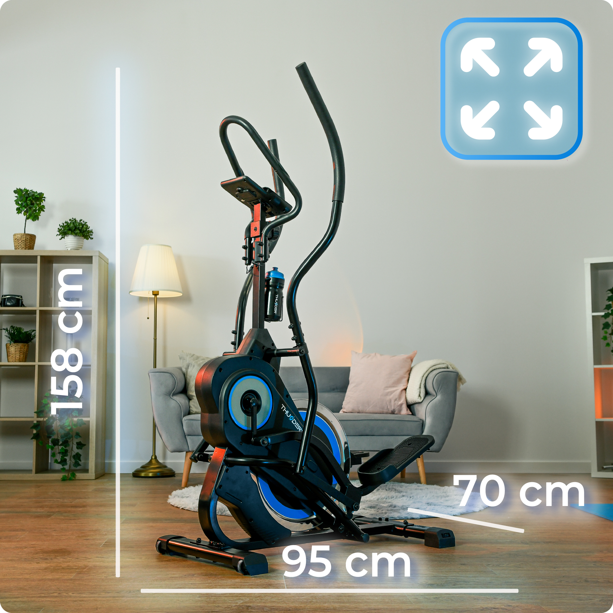 Czarno-niebieska maszyna eliptyczna. Wymiary 158 cm wysokości, 95 cm długości i 70 cm szerokości. W pokoju z meblami.