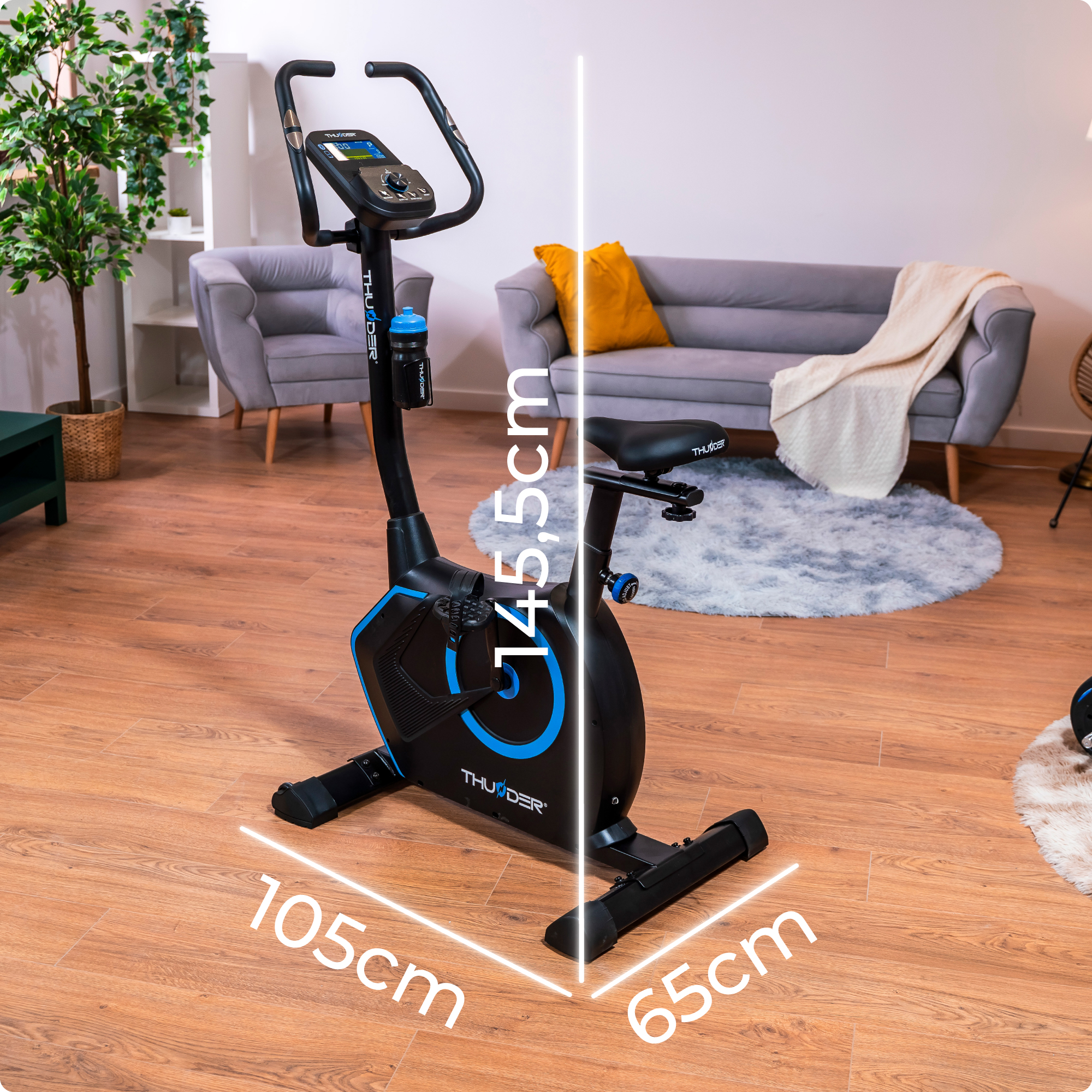 Rower treningowy w pokoju. Wymiary oznaczone: 105cm x 65cm x 145,5cm. Schemat kolorów niebiesko-czarny.