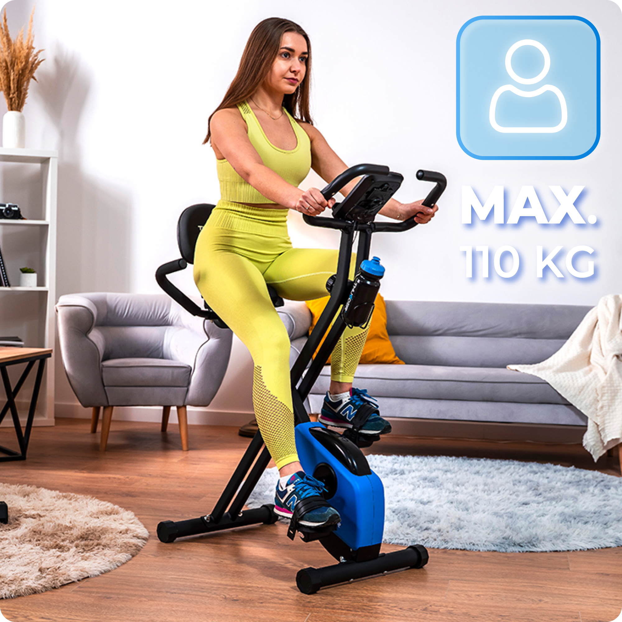 Kobieta w żółtym stroju sportowym korzysta ze składanego roweru treningowego. Tekst: max. 110 kg.