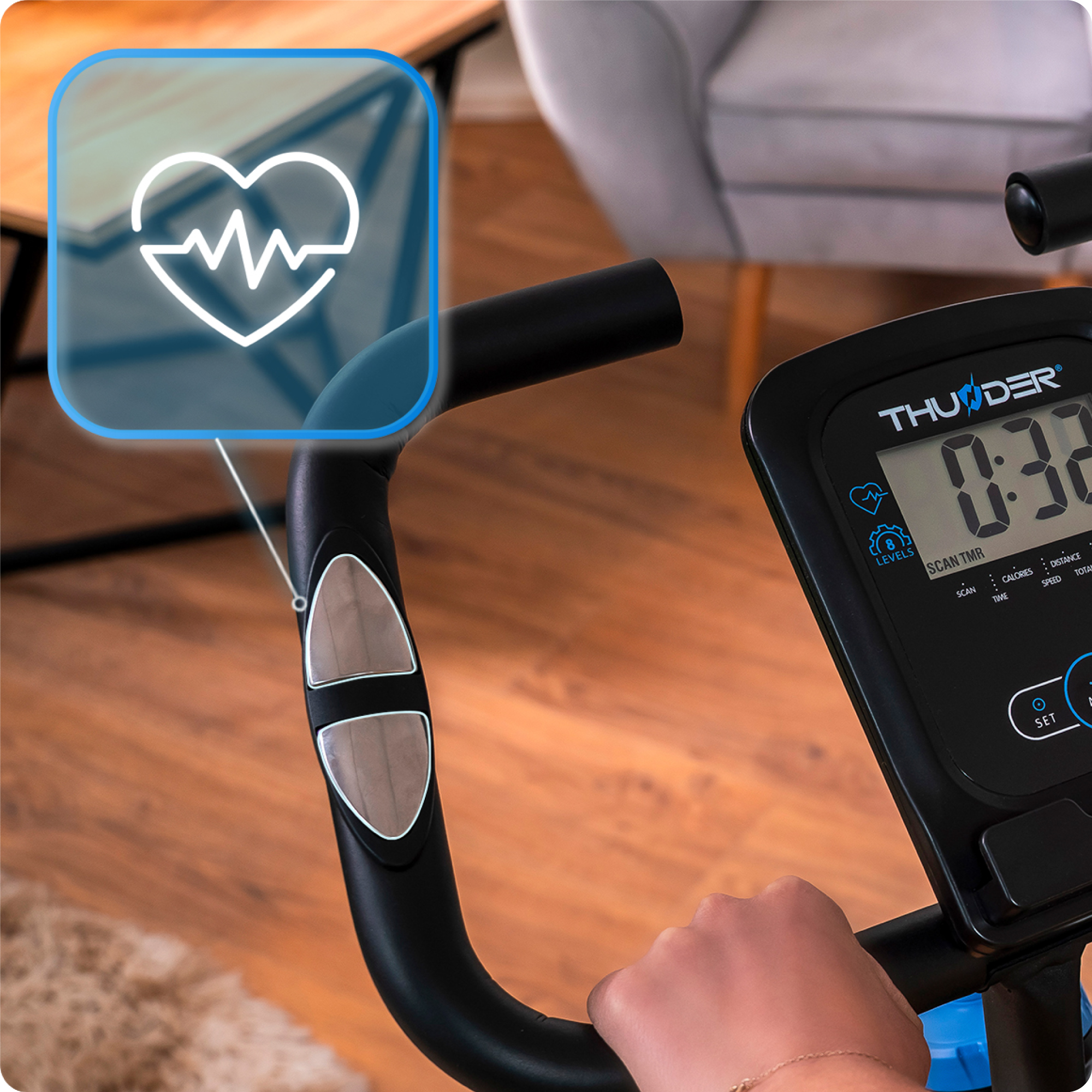 Zbliżenie kierownicy roweru treningowego. Wyświetlacz pokazuje tętno i czas.