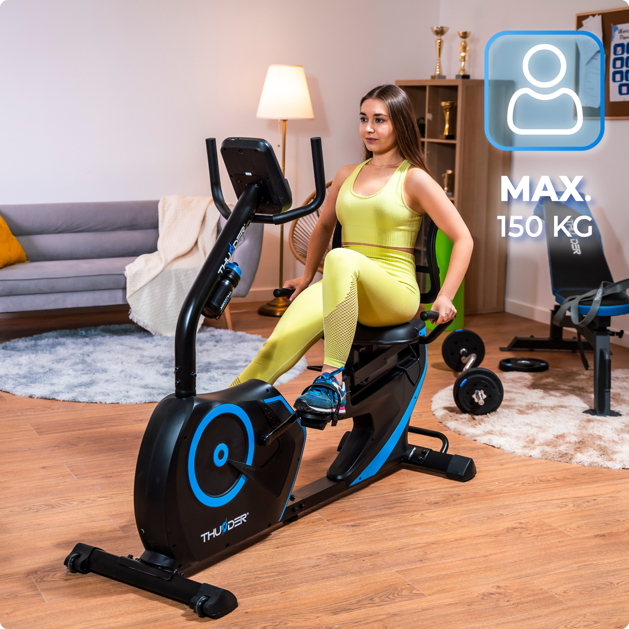 Kobieta w żółtym na rowerze poziomym, etykieta wagi max. 150 kg.