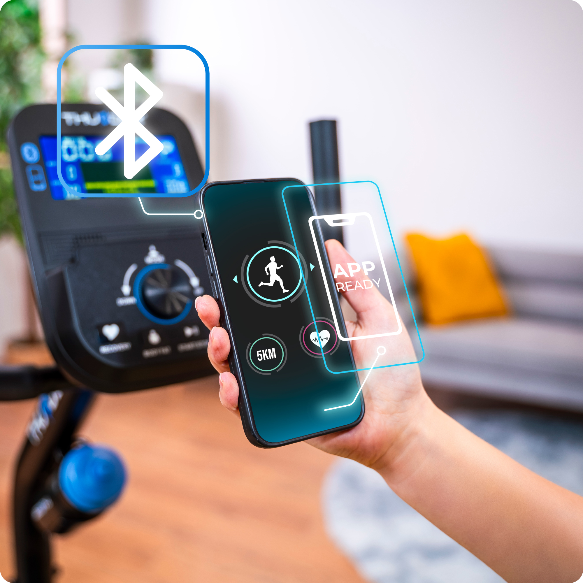 Dłoń korzystająca ze smartfona połączonego z maszyną eliptyczną.