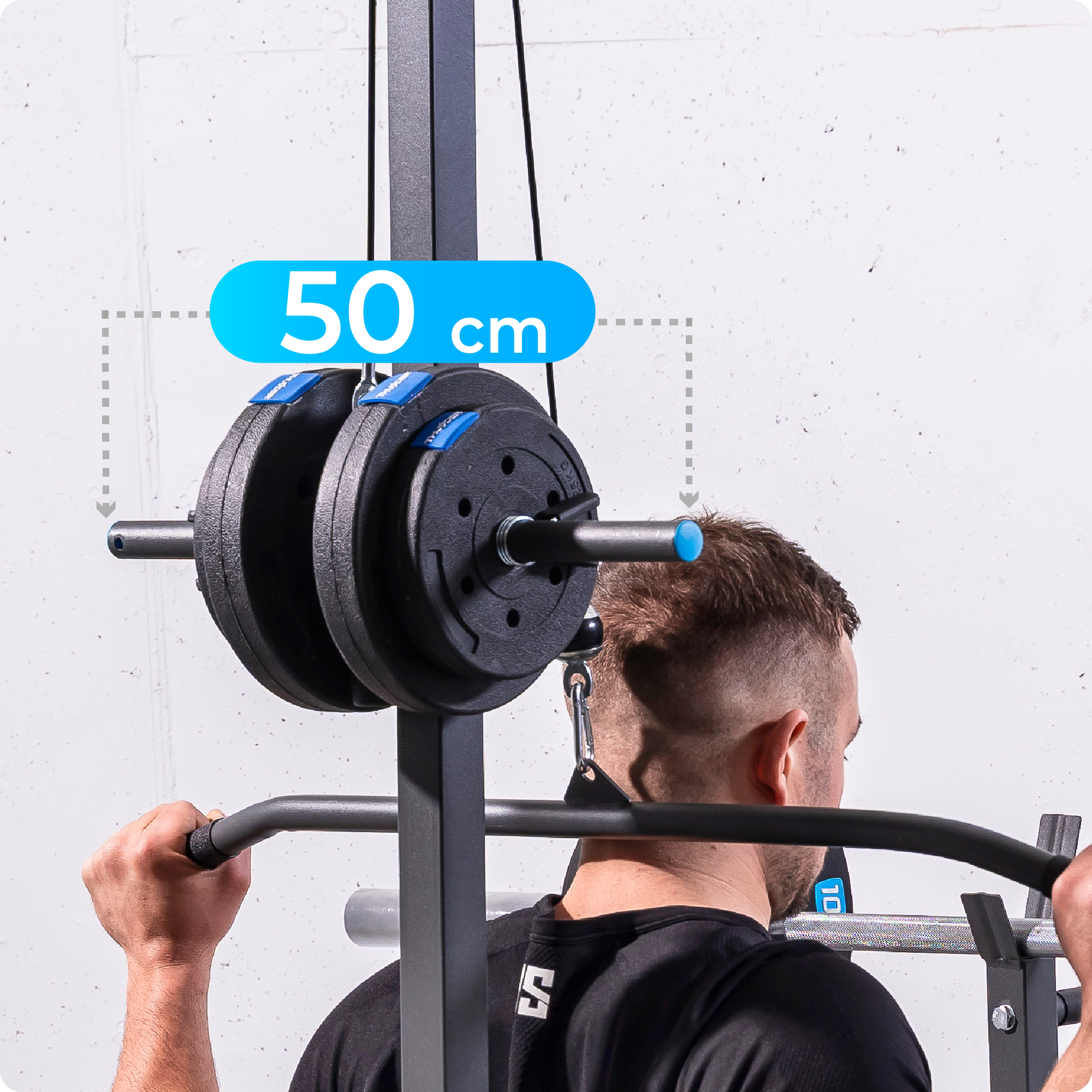 Mężczyzna wykonuje ściąganie drążka wyciągu górnego na maszynie do ćwiczeń. Widoczne obciążenia.