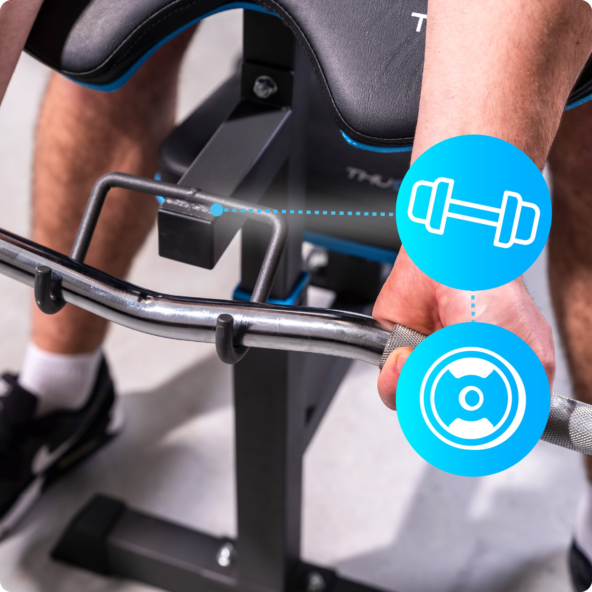 Zbliżenie maszyny do ćwiczeń z drążkiem. Ręka trzyma drążek. Pokazano ikonę hantli i ikonę wagi.