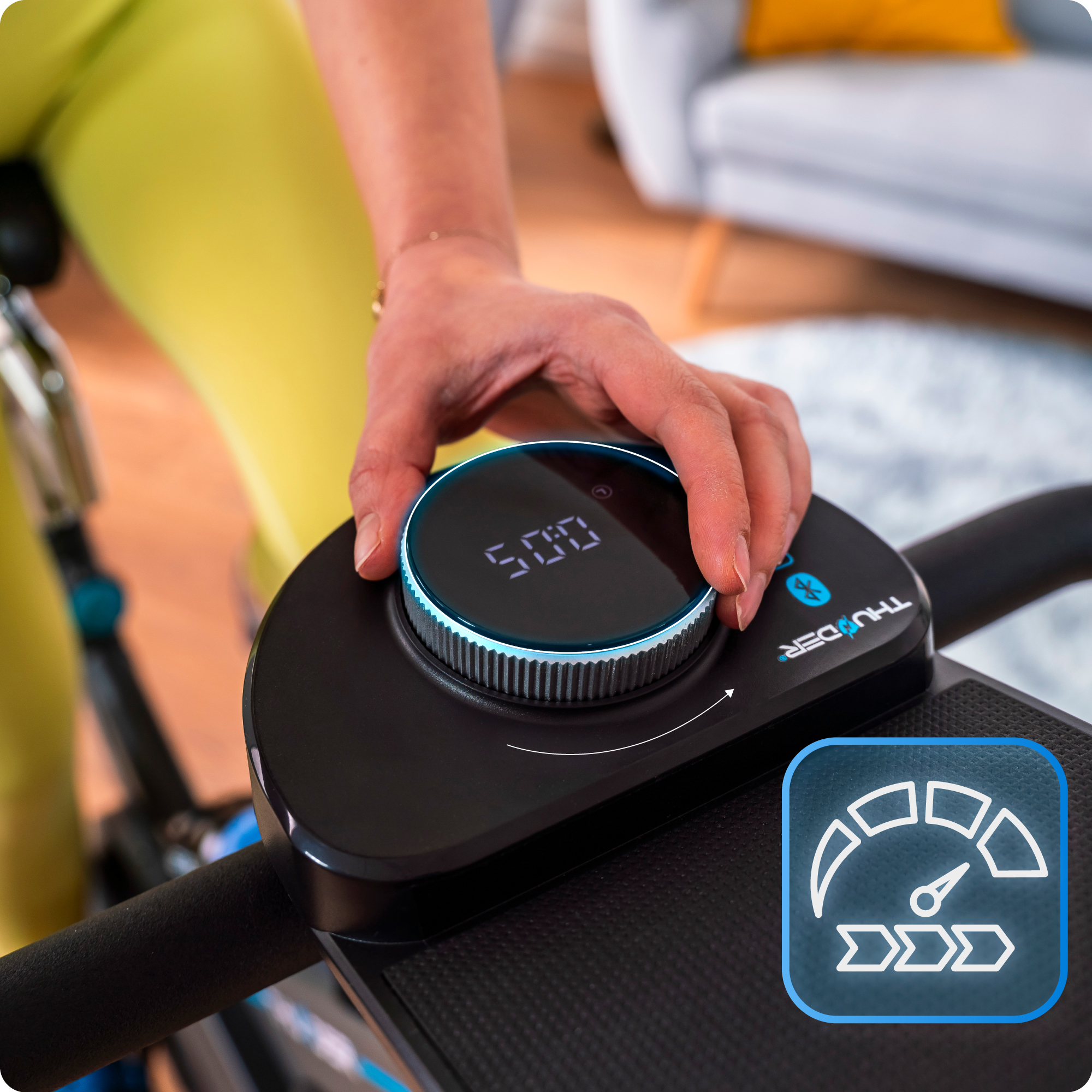 Ręka regulująca panel sterowania roweru treningowego. Panel wyświetla 5.00.