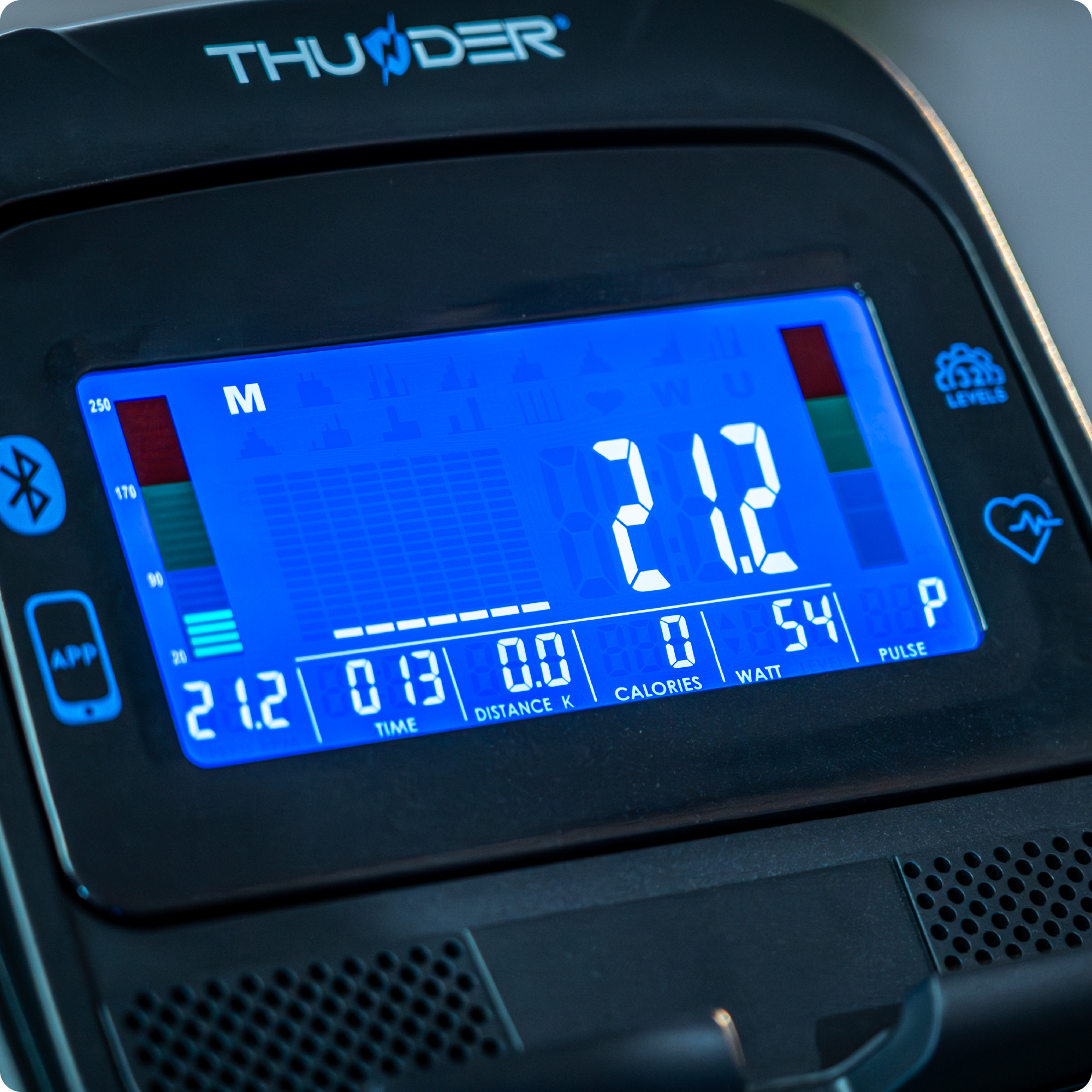 Zbliżenie na ekran trenażera eliptycznego, pokazujący czas, dystans, kalorie i inne dane treningowe.