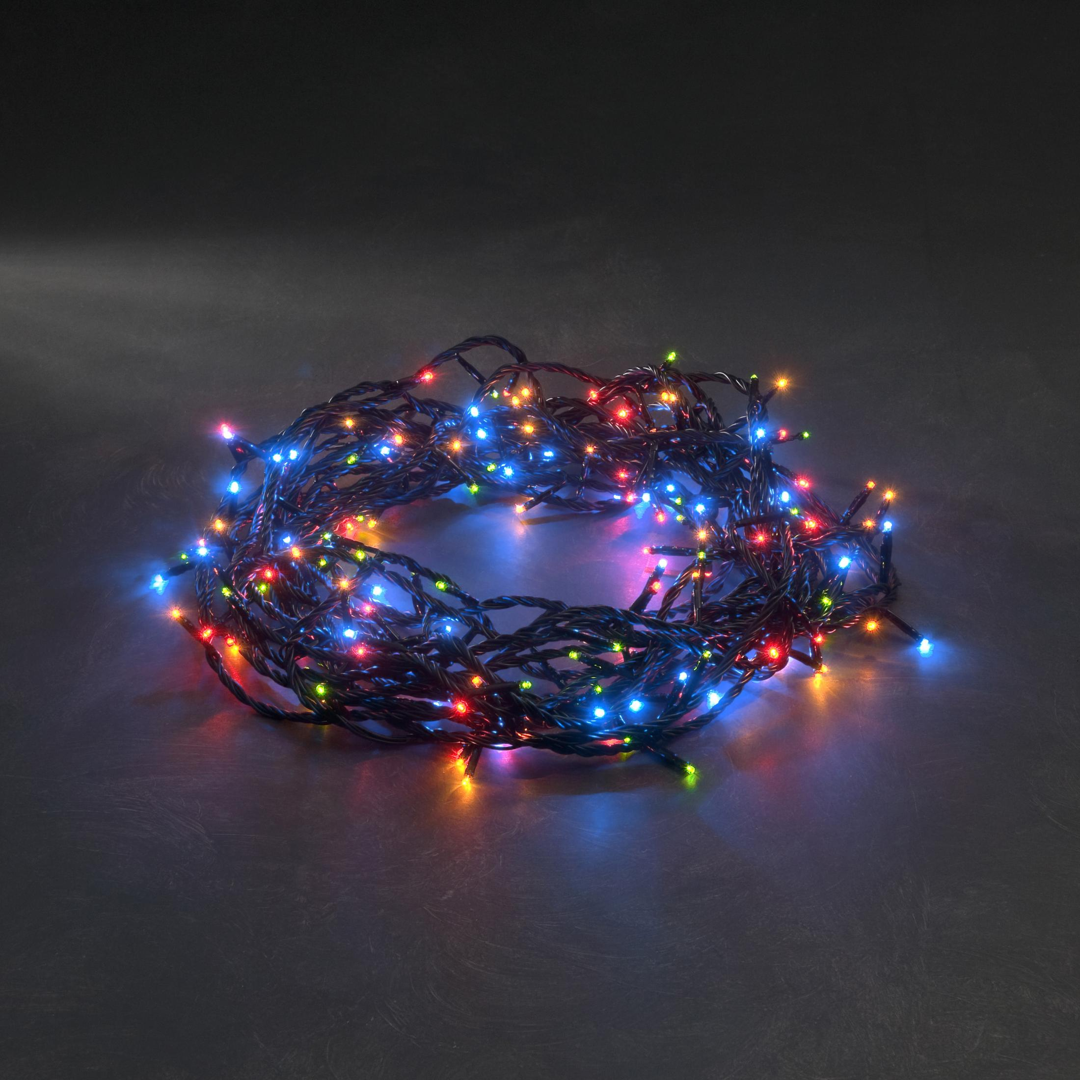 Una catena aggrovigliata di luci natalizie, con luci rosse, verdi, blu e gialle. Sfondo grigio scuro.