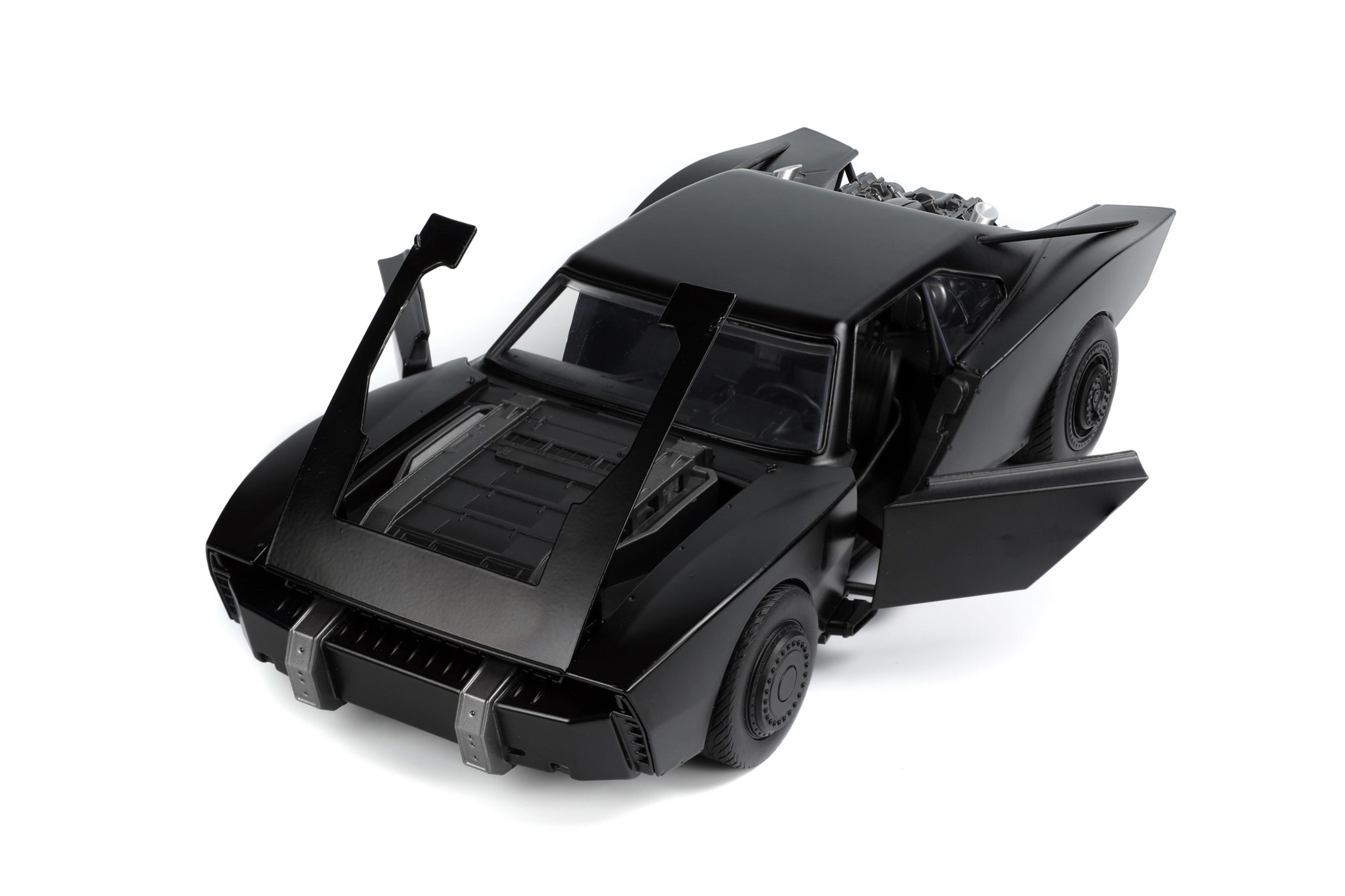 Ein schwarzes Spielzeug-Batmobil mit offenen Türen, das das Innere und den Motor des Autos zeigt.