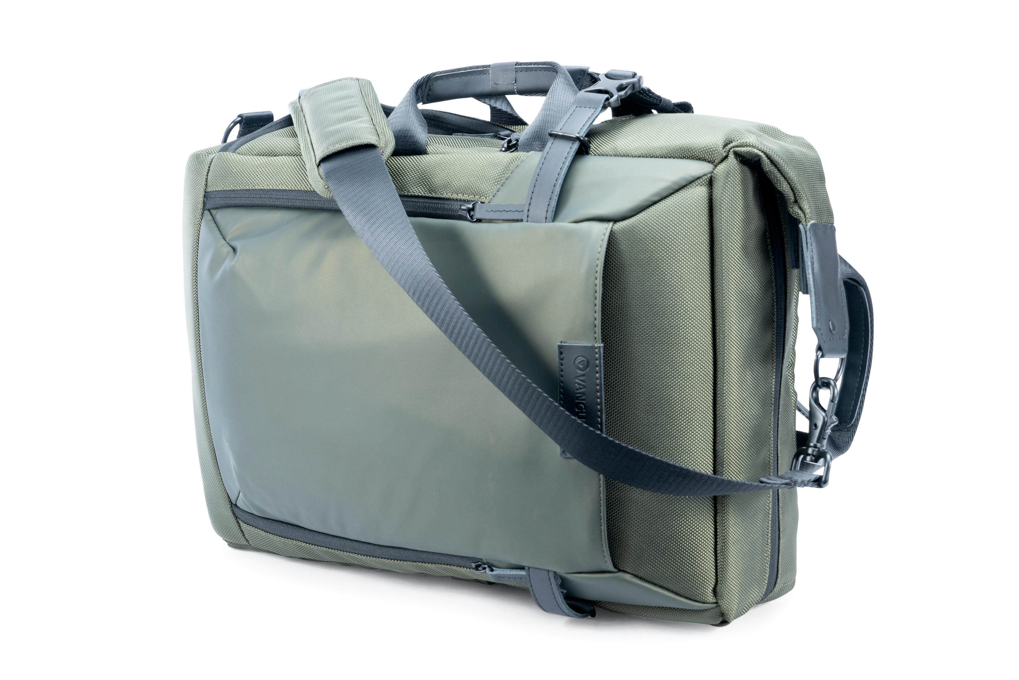 Eine olivgrüne Tasche mit Schultergurt auf weißem Hintergrund. Sie hat einen Griff und eine Tasche.