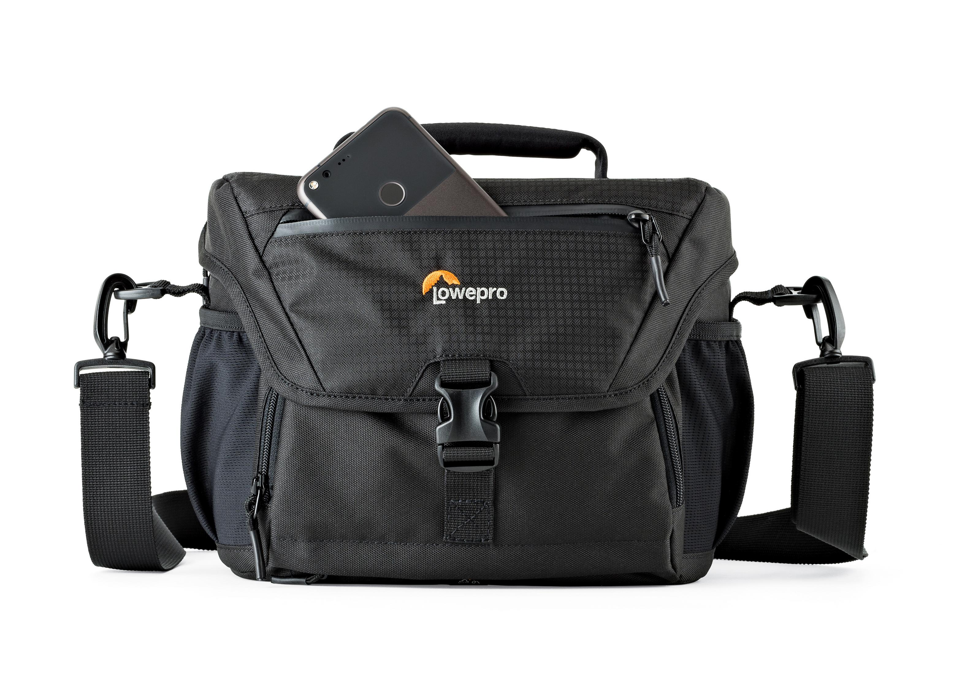 A black camera bag with a phone in the top pocket. It has a handle and a shoulder strap.