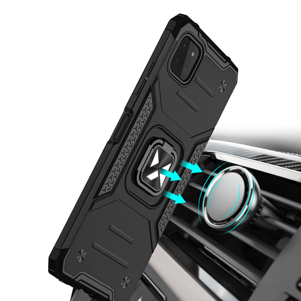 Czarne etui na telefon z metalowym pierścieniem. Etui jest zamontowane na kratce wentylacyjnej samochodu.