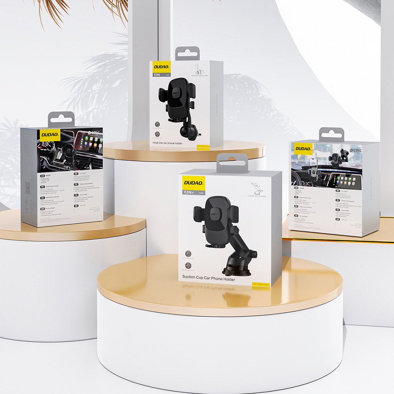 Cztery pudełka uchwytów do telefonów samochodowych DUDAO na wystawie. Znajdują się na złotej i białej platformie.