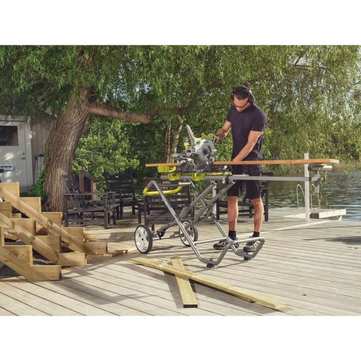 Ein Mann benutzt eine Gehrungssäge auf einem Holzdeck. Die Säge ist silber und gelb.
