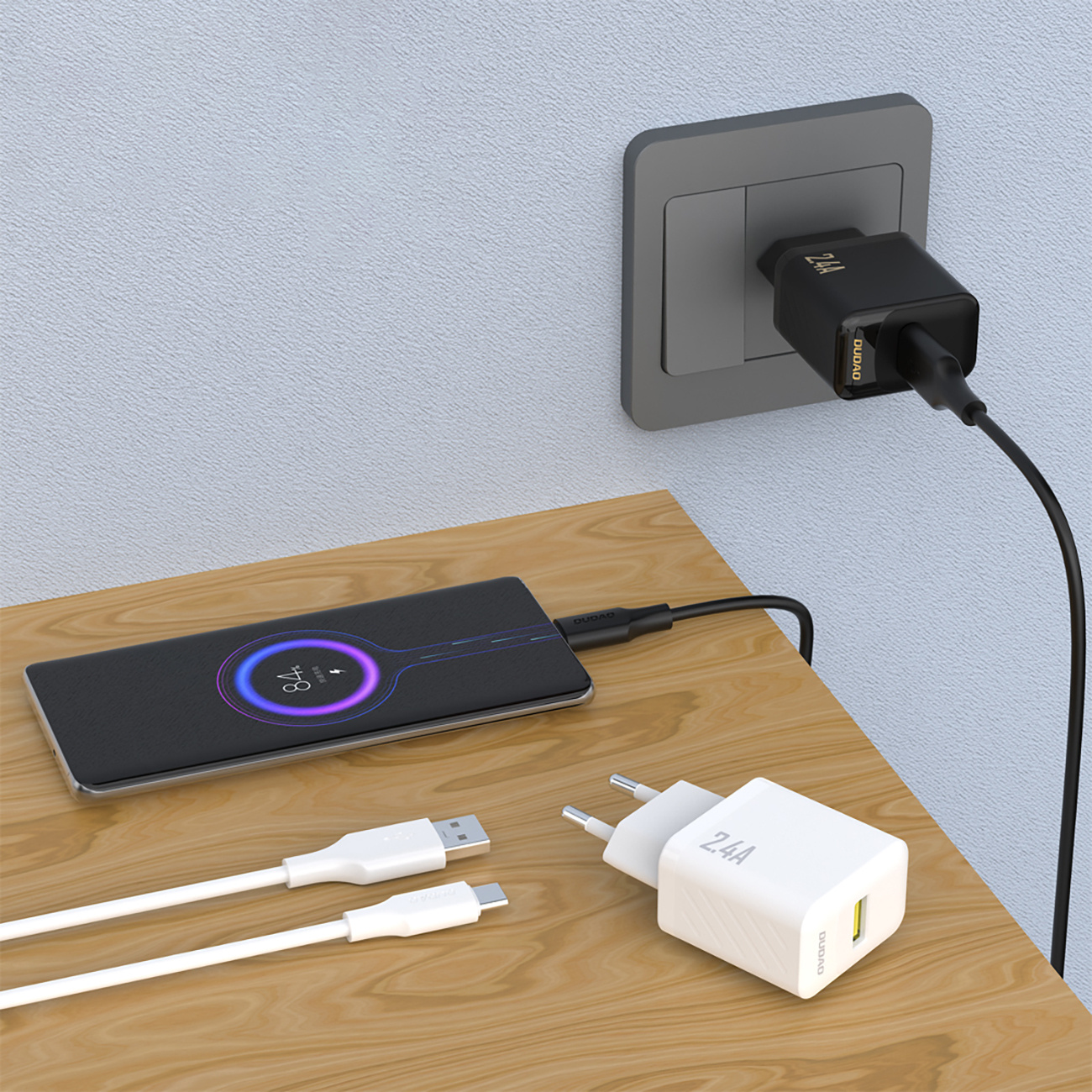 Telefon ładujący się z białą ładowarką w gniazdku w ścianie.