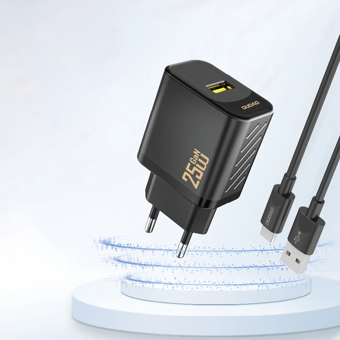 Czarna ładowarka z kablem. Ładowarka ma żółty port. Tło jest jasnoniebieskie.