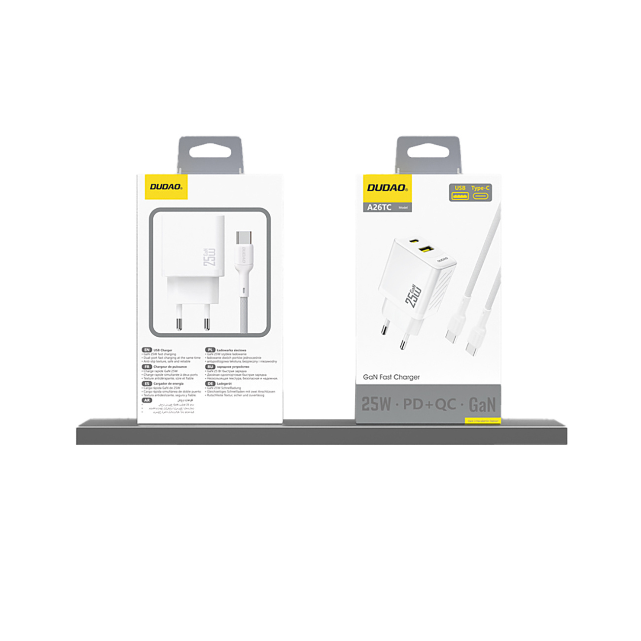 Dwa białe pudełka z ładowarkami i kablami na półce. Marka to 'DUDAD'.