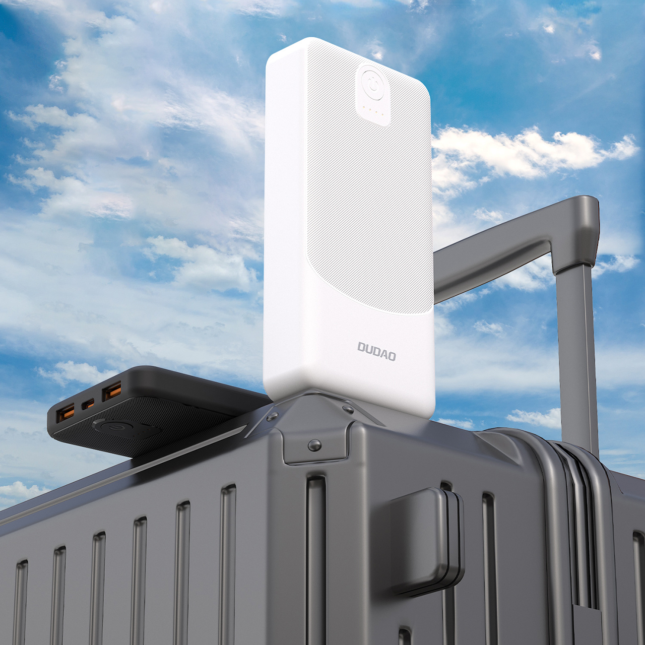 Biały power bank na walizce. Czarny telefon umieszczono obok power banku.