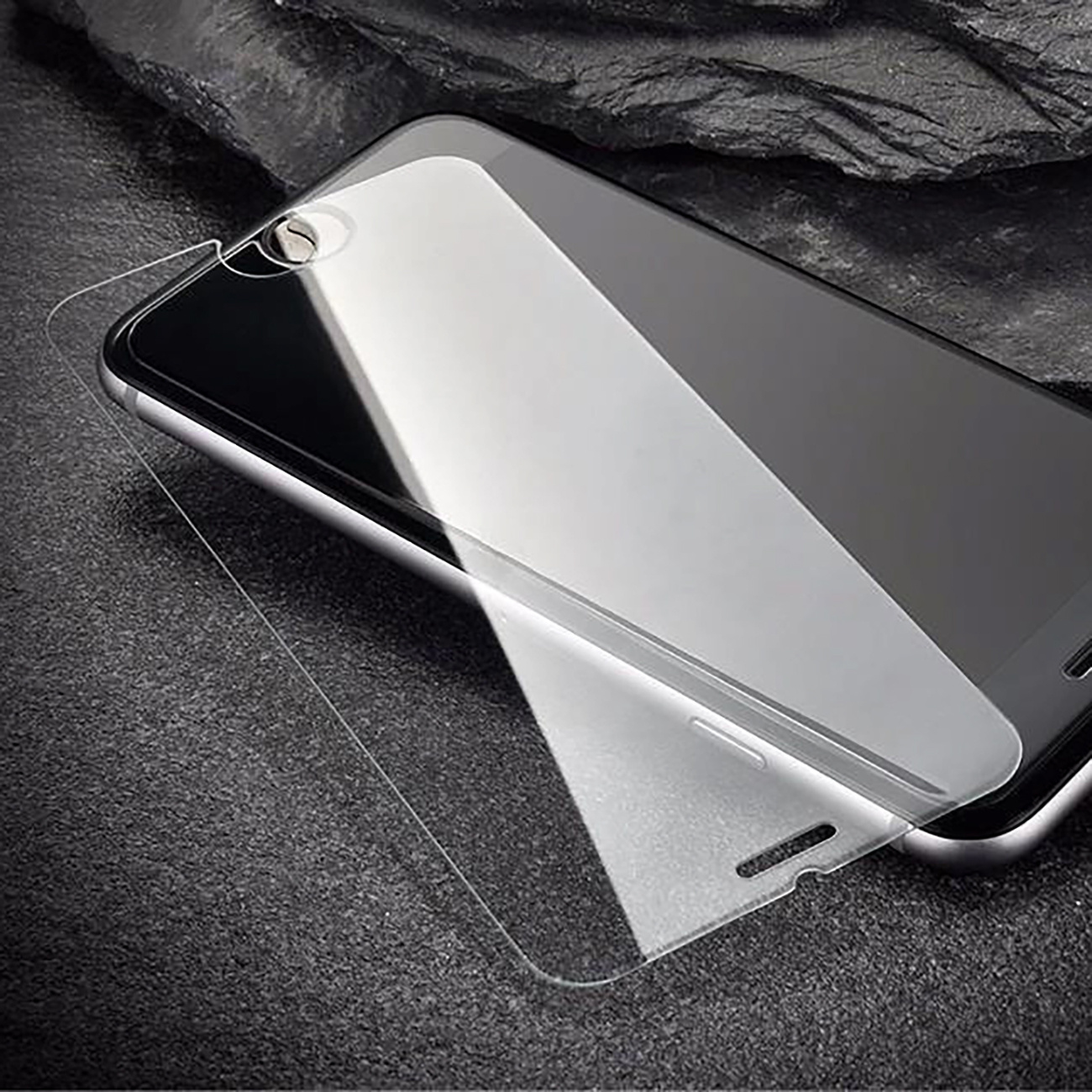 Smartfon z ochraniaczem ekranu jest wyświetlany na ciemnoszarej powierzchni.