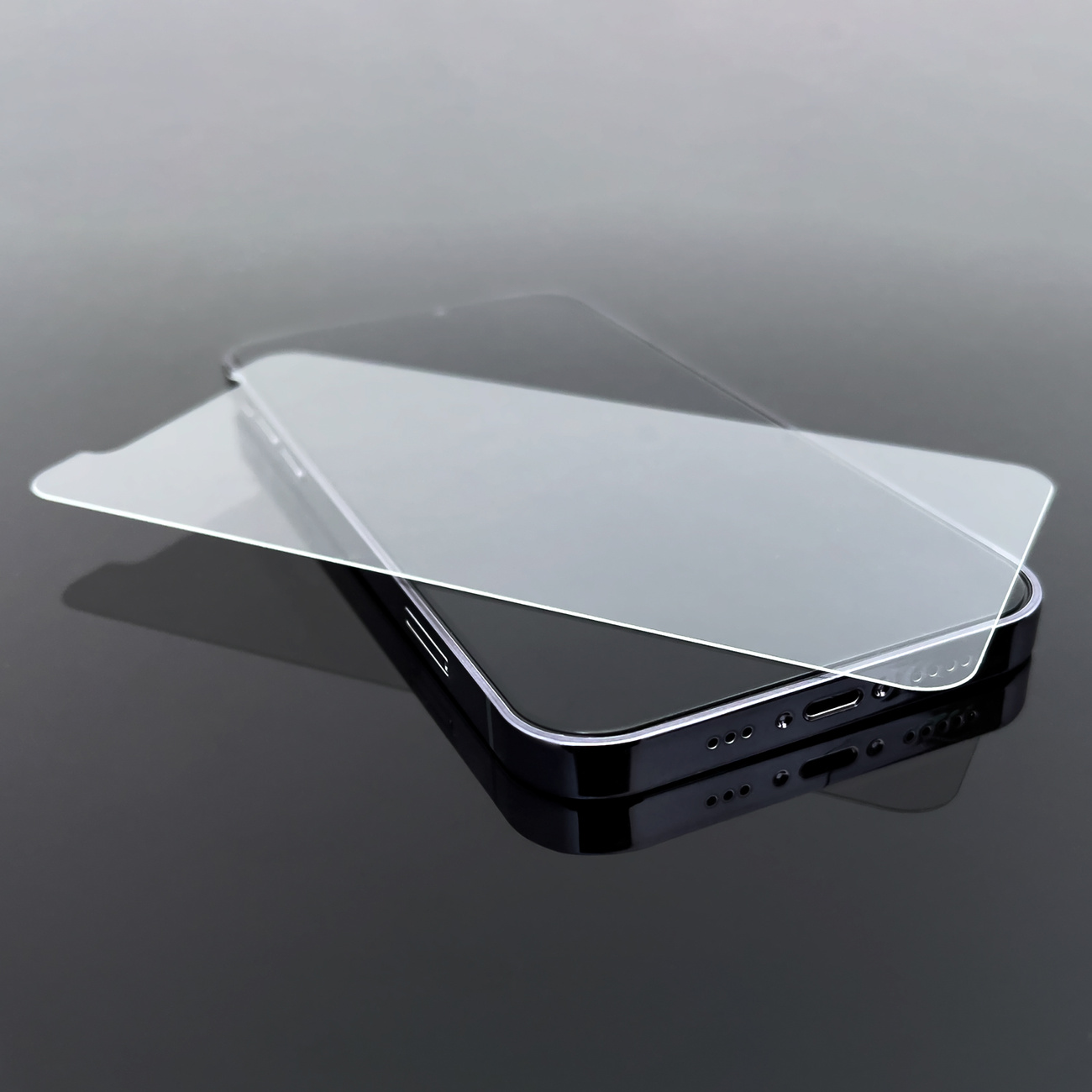 Smartfon z naklejoną osłoną ekranu. Telefon jest czarny, ochrona jest przezroczysta.
