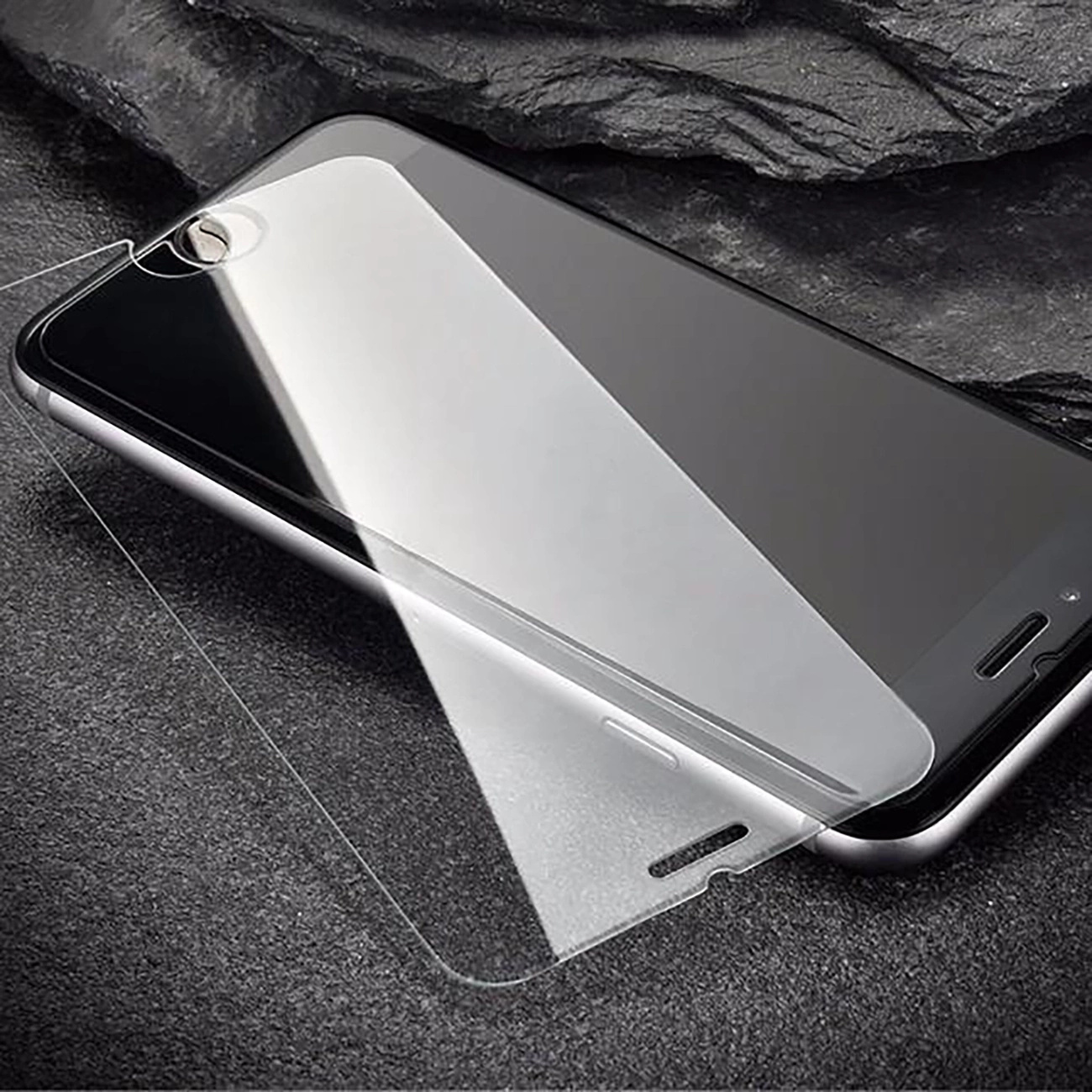 Smartfon z nałożoną folią ochronną na tle ciemnym i teksturowanym.