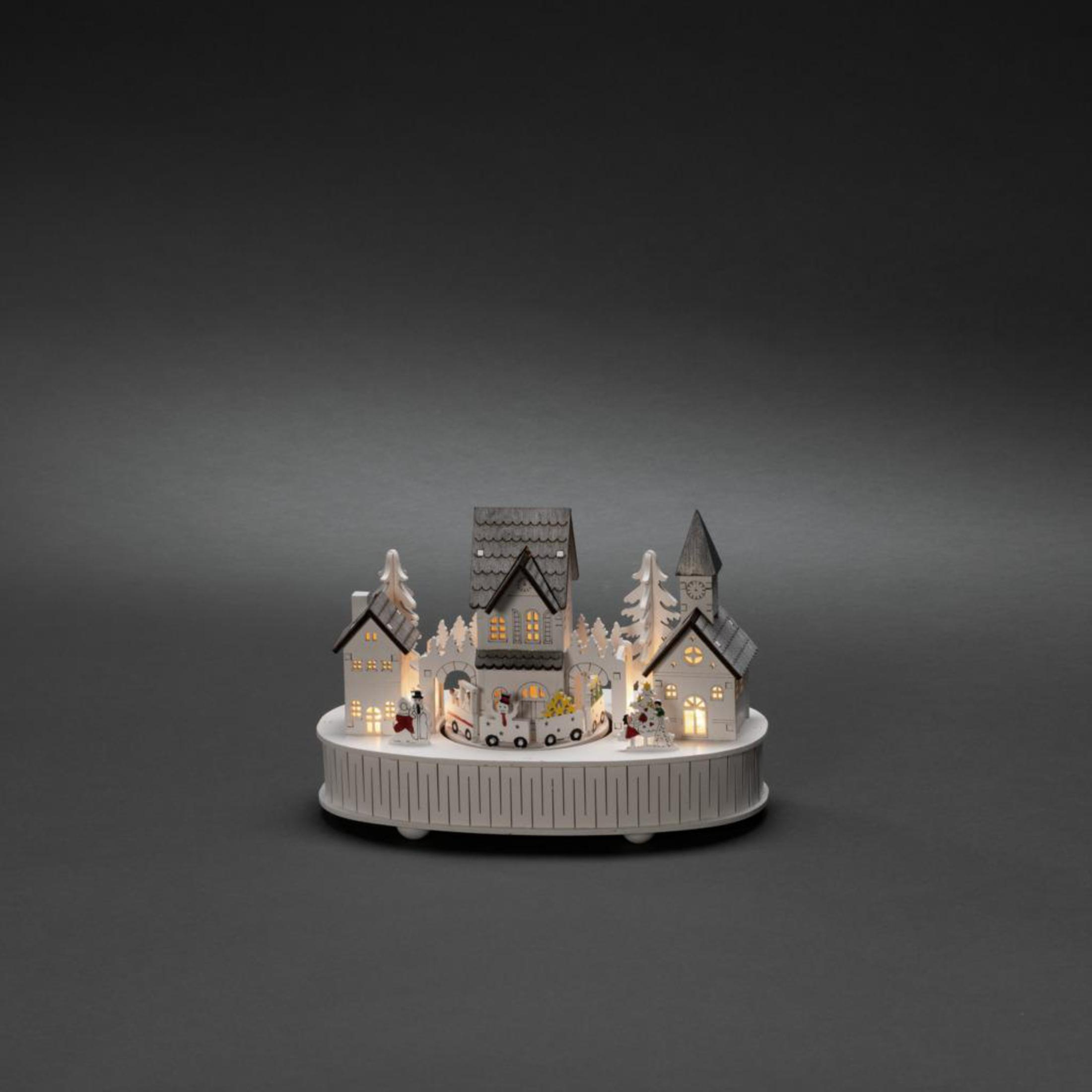 Weihnachtsdorf-Display mit beleuchteten Häusern und Bäumen. Schneemänner und Figuren auf weißer Basis.