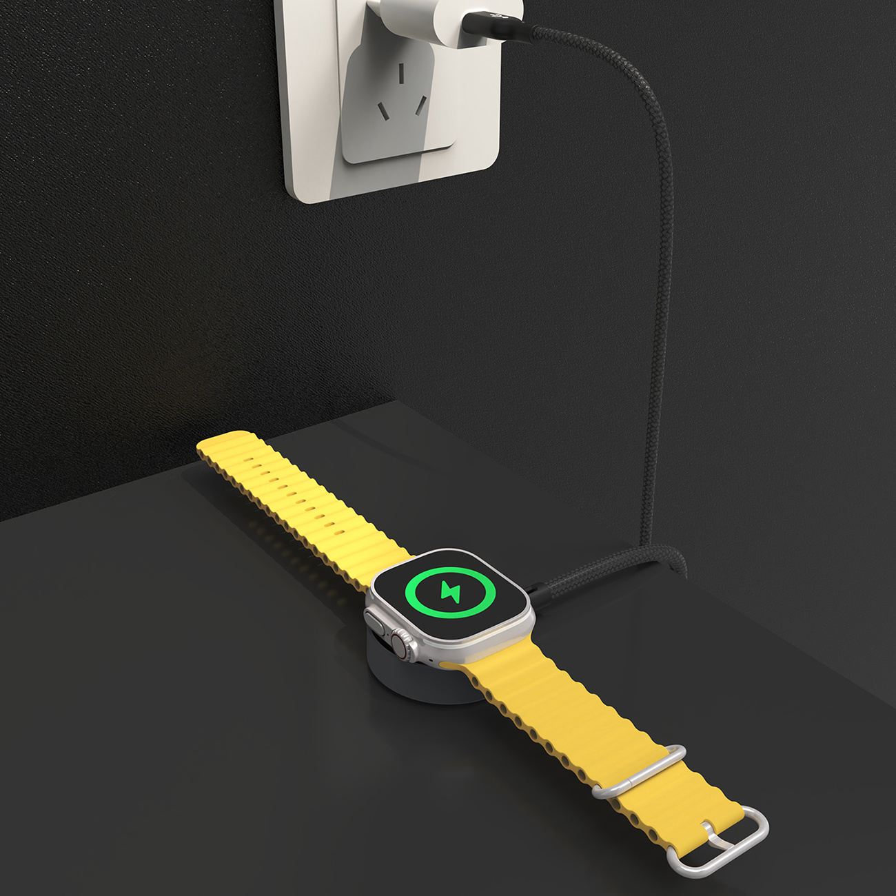 Żółty smartwatch ładuje się na czarnej powierzchni. Ładowarka jest podłączona do białego gniazdka ściennego.