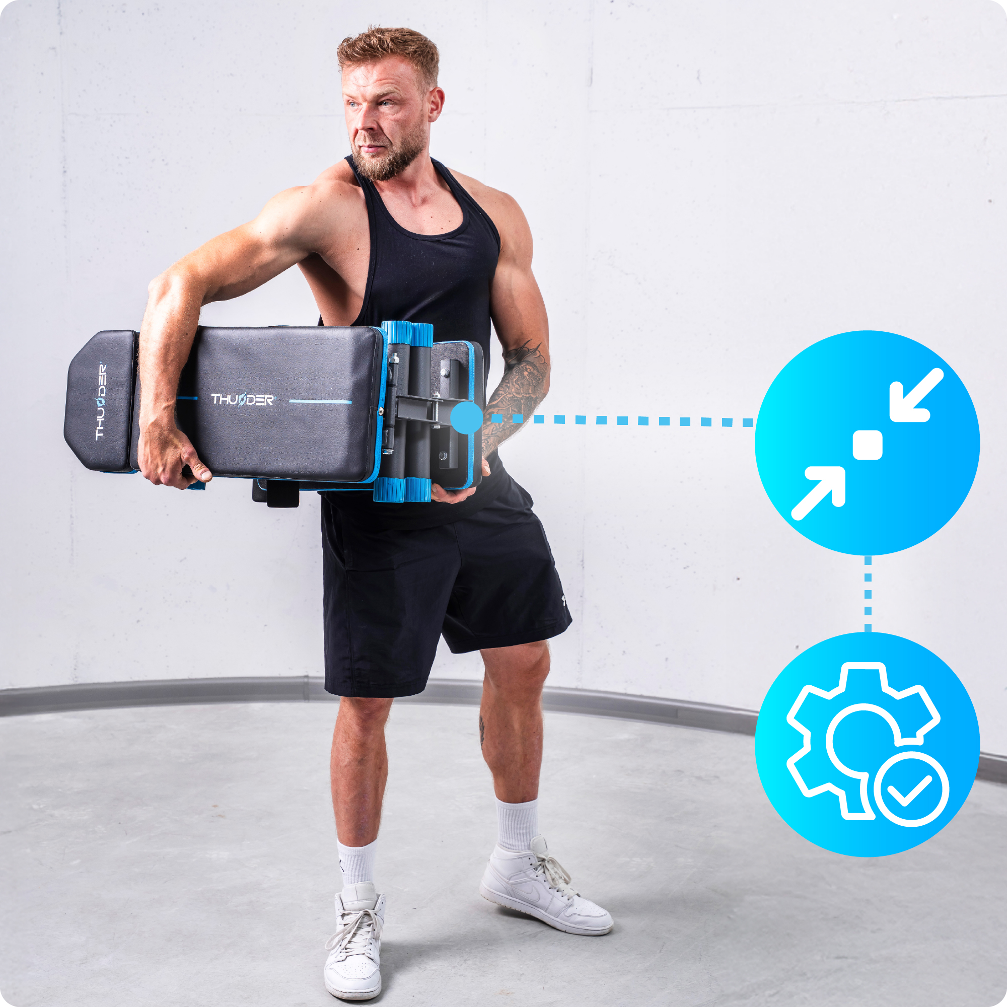 Mężczyzna trzymający czarno-niebieską ławkę do ćwiczeń. Ma na sobie czarne szorty i koszulkę.