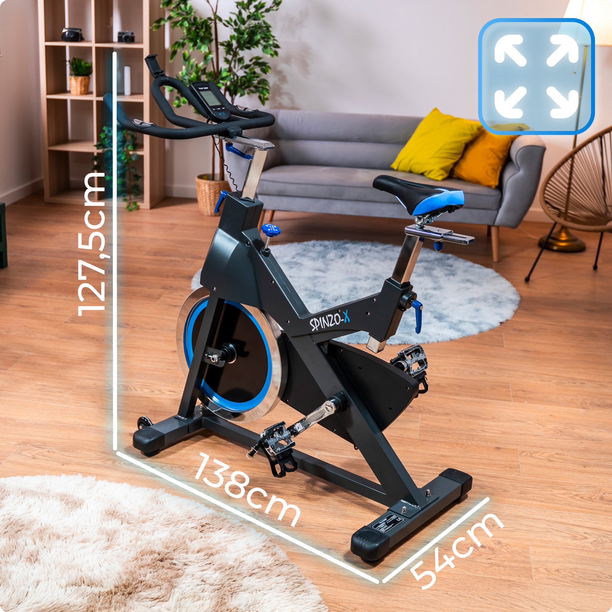 Rower stacjonarny. Czarny i niebieski z wymiarami. Salon z sofą w tle.