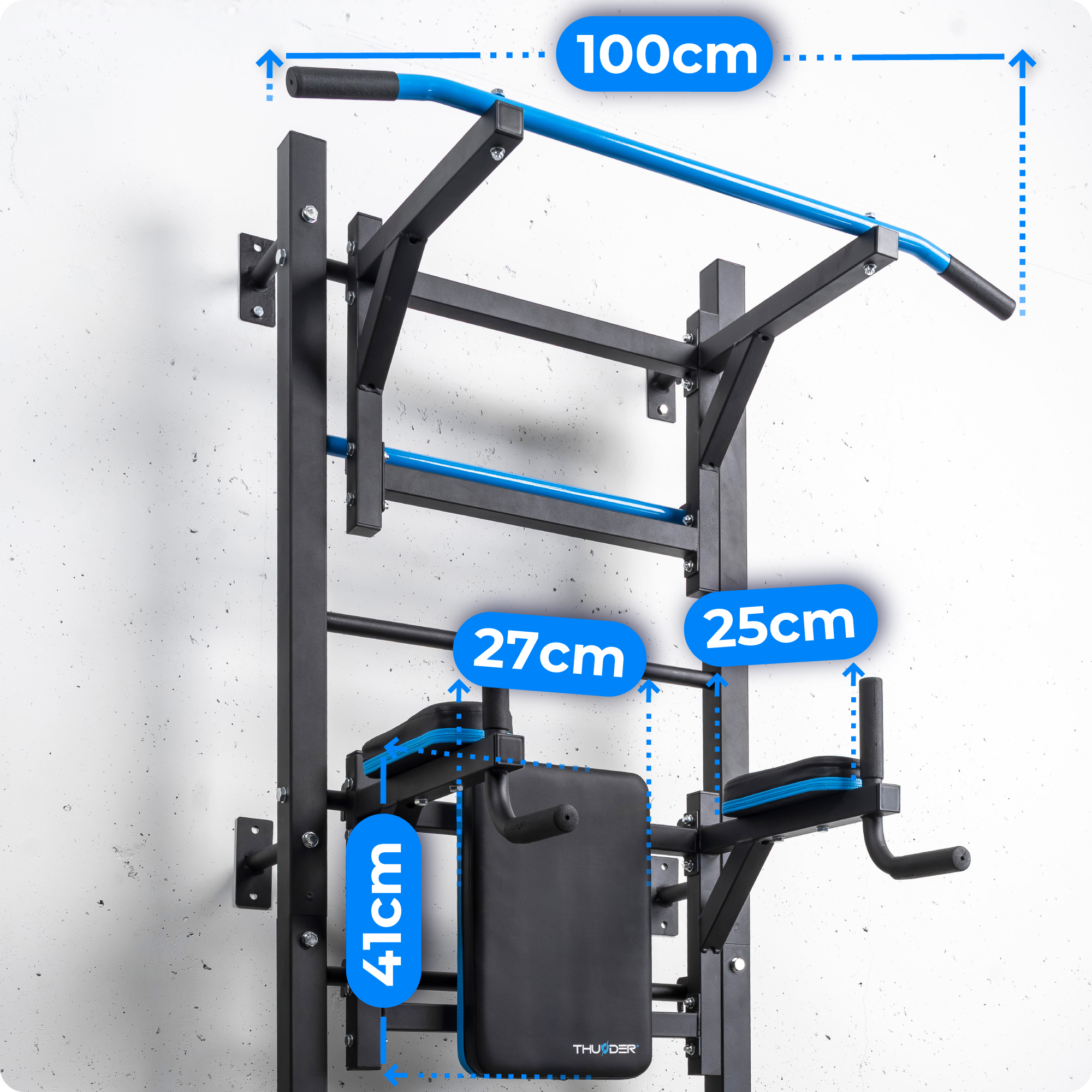Montowana na ścianie stacja treningowa z wymiarami. Posiada drążek do podciągania, poręcze i ławkę. Niebieskie akcenty.