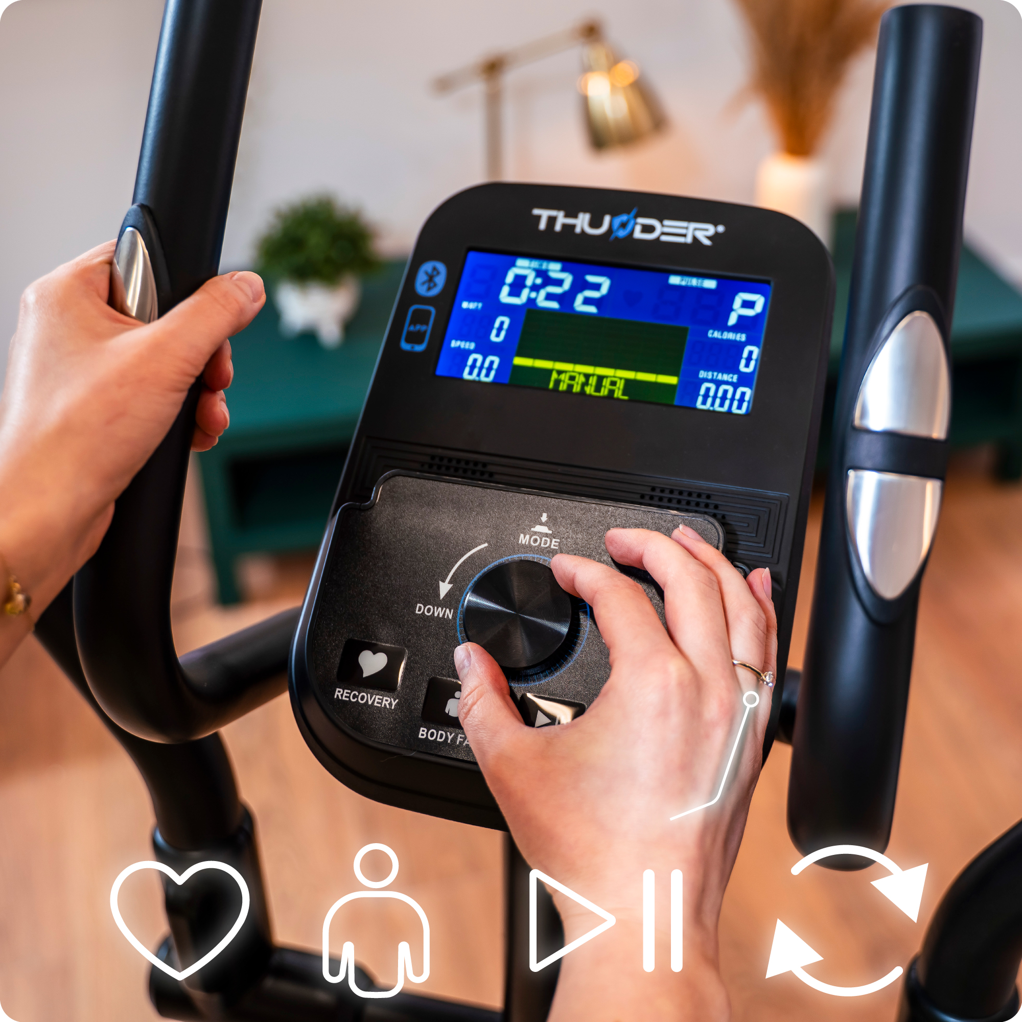 Zbliżenie dłoni na panelu sterowania maszyny eliptycznej. Pokazuje prędkość, czas i inne dane.