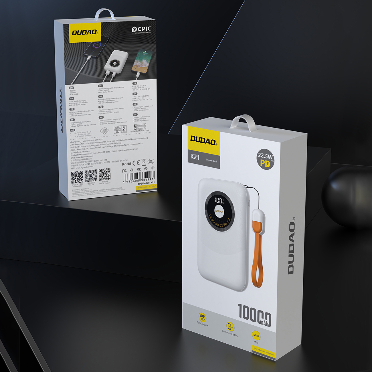 Biało-pomarańczowe pudełko power banku, z białym power bankiem po prawej stronie, na czarnym tle.