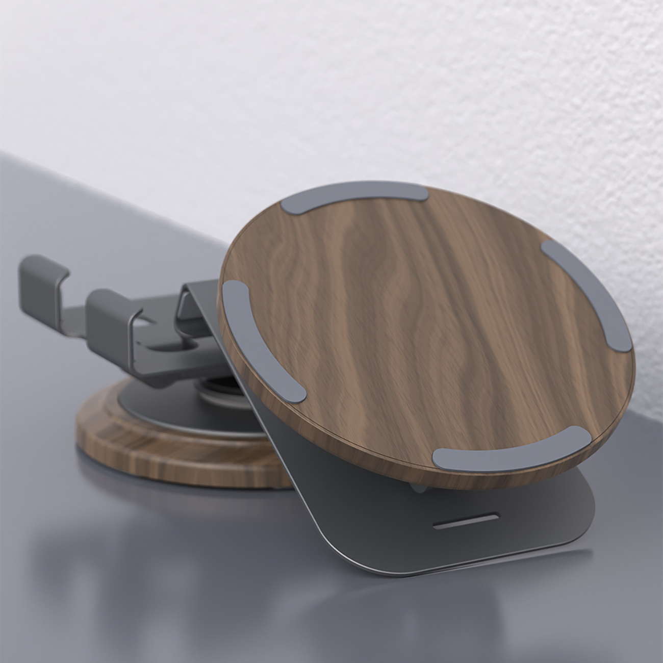 Drewniany stojak na telefon z metalową ramą. Stojak stoi na odblaskowej powierzchni.