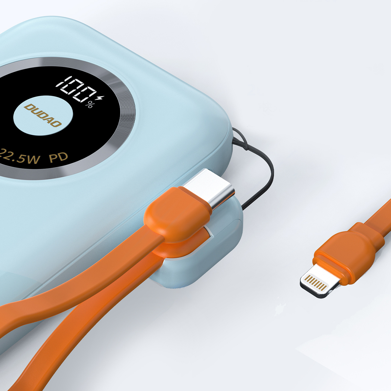 Niebieska ładowarka z pomarańczowymi kablami. Ładowarka pokazuje 100% oraz napisy DUDO i 22,5W PD.