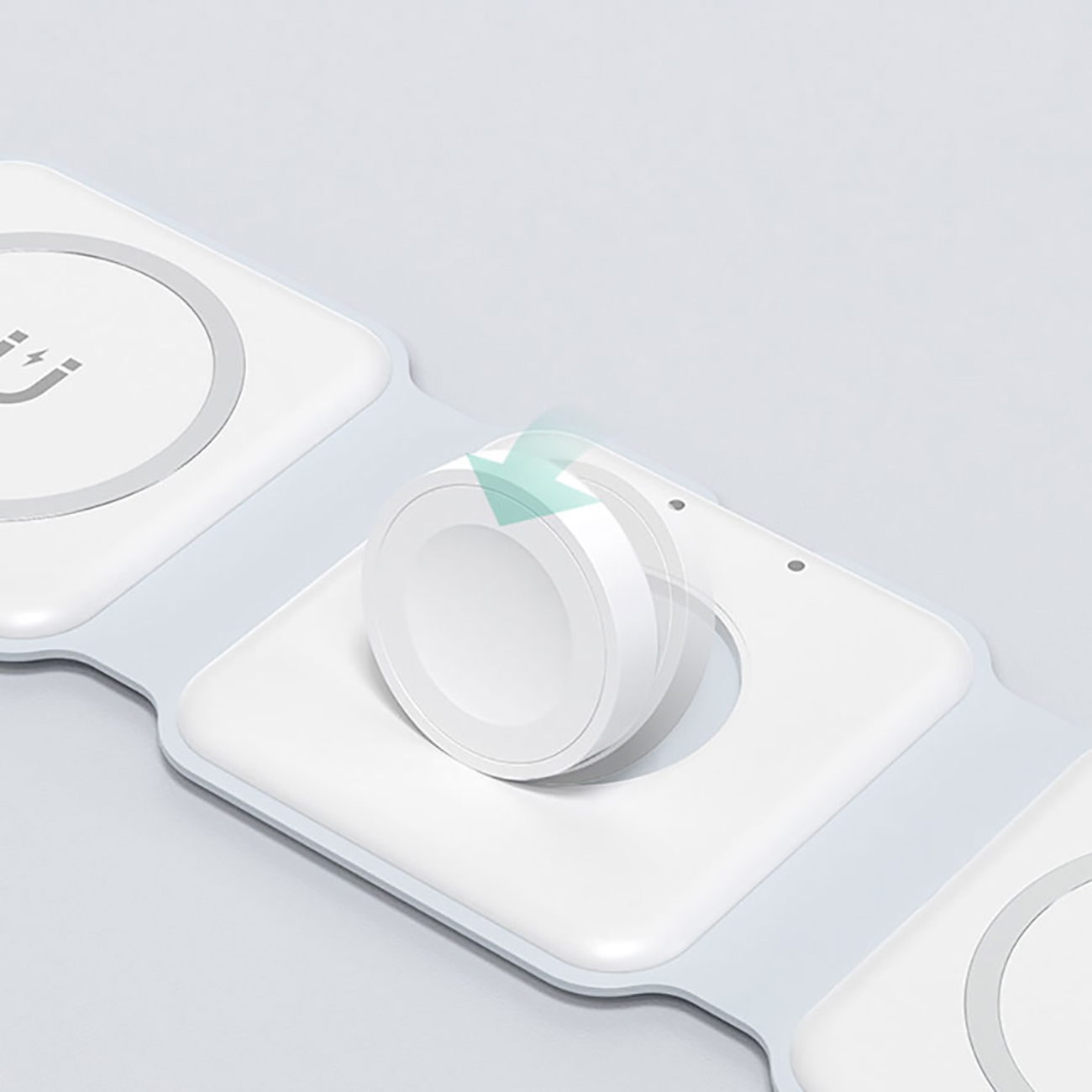 Biała podkładka ładująca z zegarkiem na górze. Strzałka pokazuje, że podkładka ładuje zegarek.