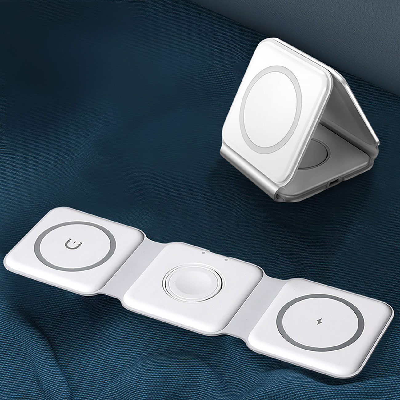 Złożona biała ładowarka. Podkładka ładująca z miejscem na zegarek. Kolejna podkładka ładująca z ikoną ładowania.