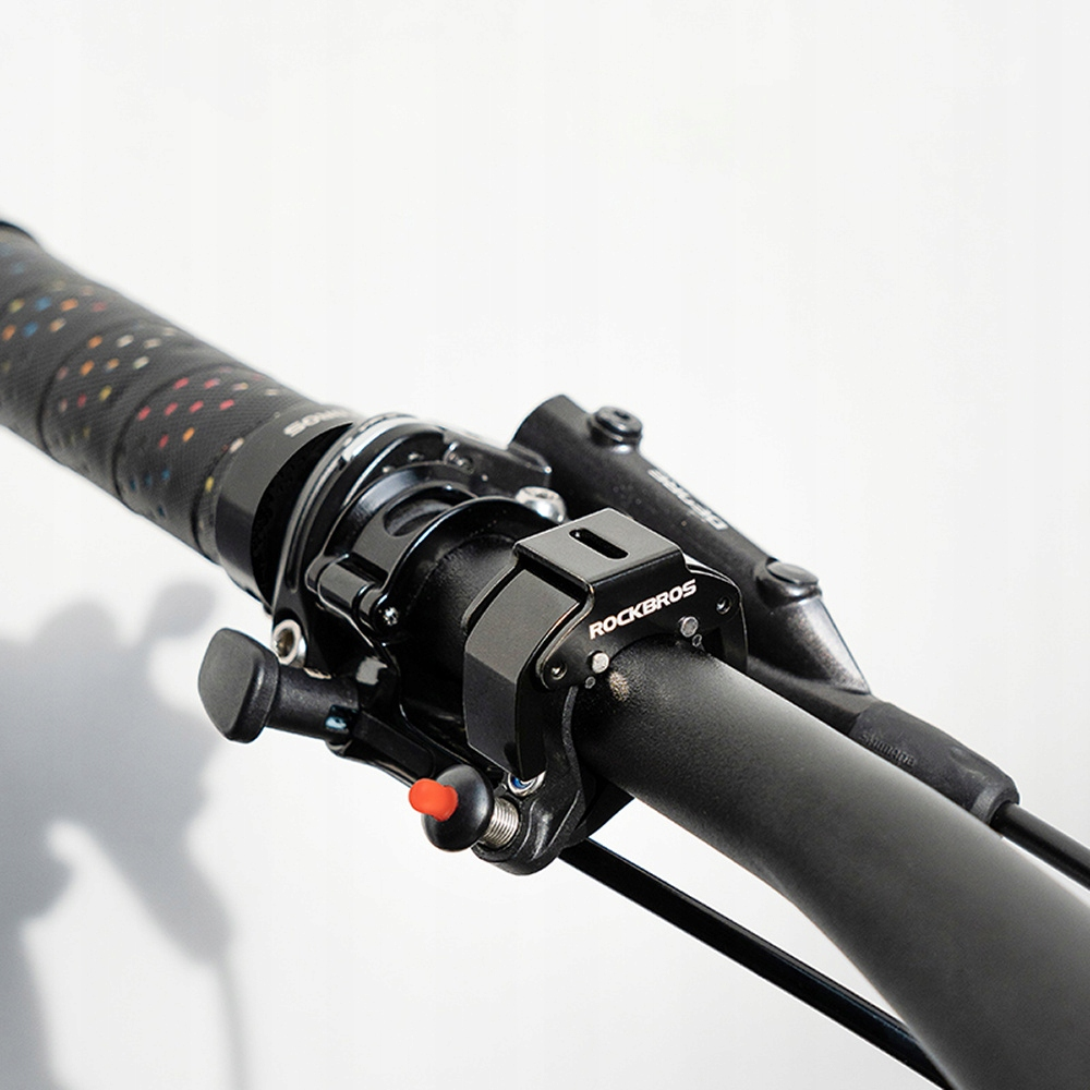 Kierownica roweru z czarnym uchwytem ROCKBROS. Uchwyt ma czerwony przycisk.