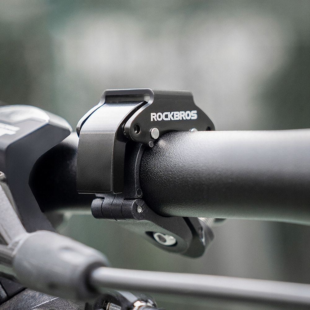 Czarny uchwyt rowerowy przymocowany do kierownicy. Napis Rockbros.
