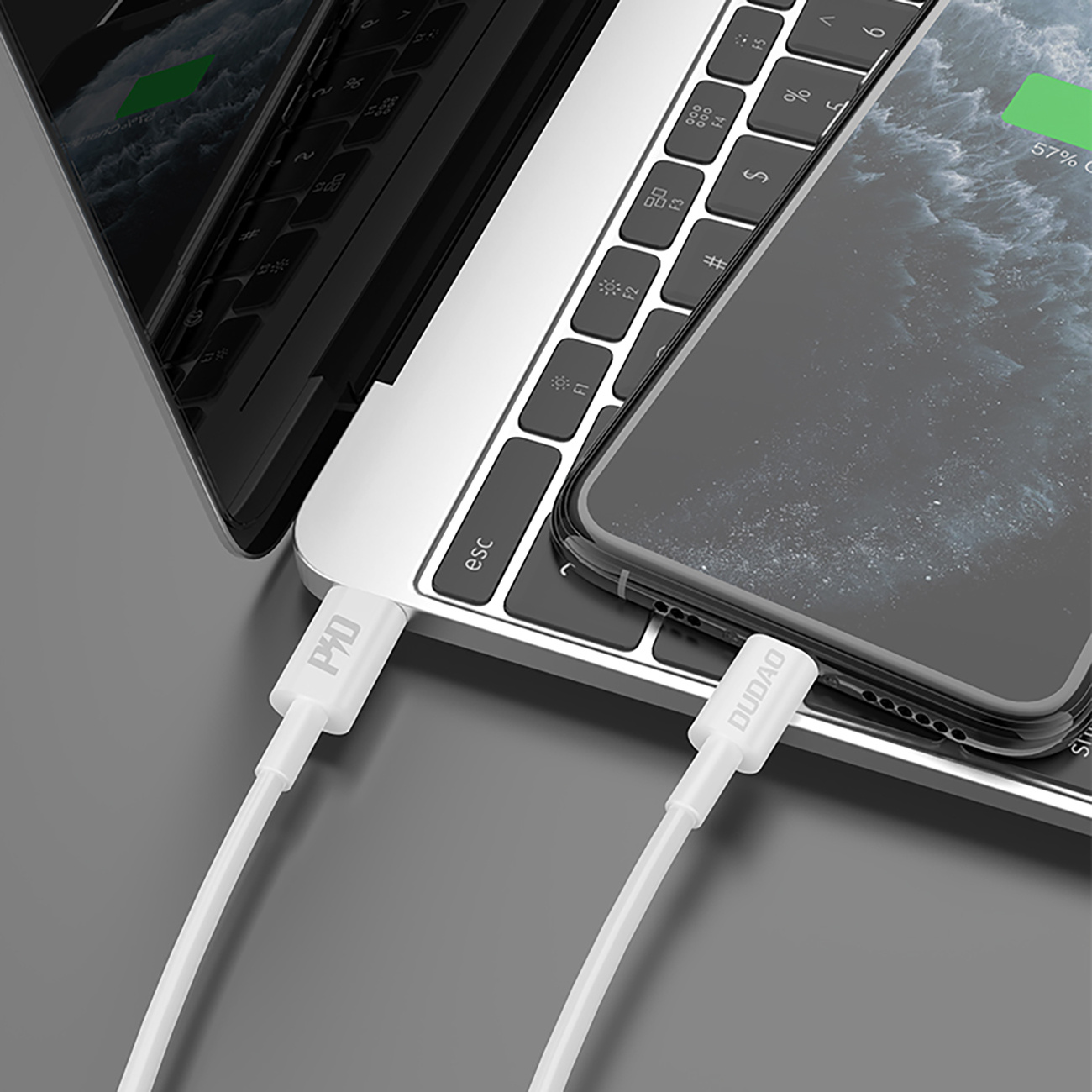 Laptop i telefon ładujące się za pomocą białych kabli USB. Widoczne loga DUDOA i P4D.