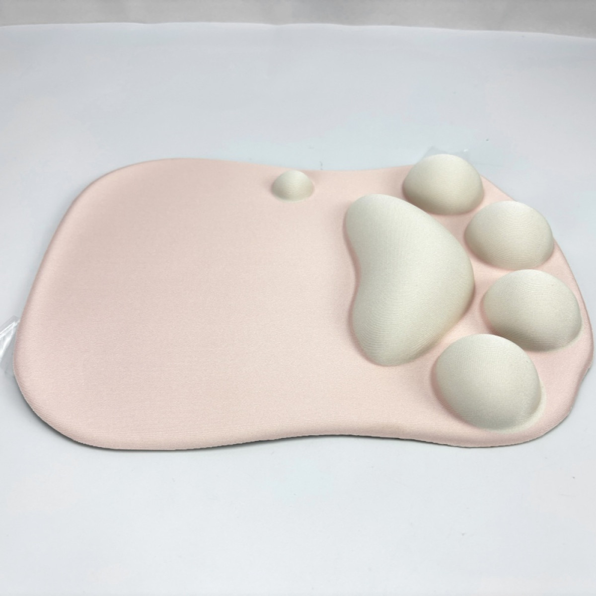 Rosa Mousepad mit weißen, kissenartigen Formen. Das Pad befindet sich auf weißem Hintergrund.