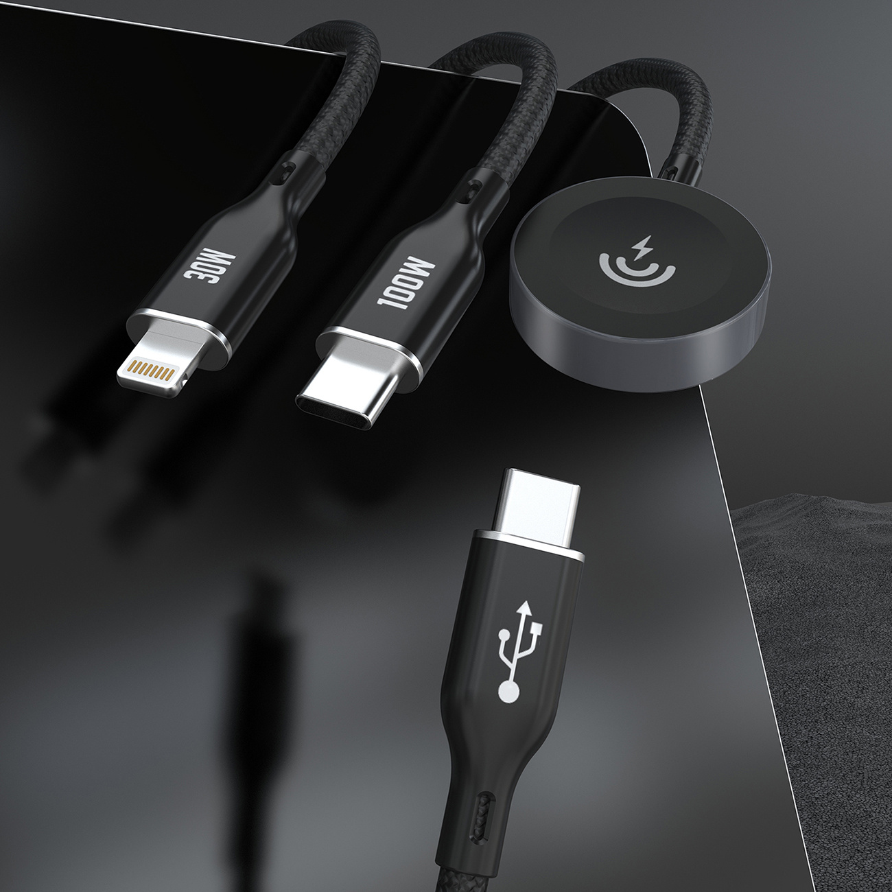 Czarne kable ładujące i bezprzewodowa podkładka ładująca. Kable z złączami USB-C i Lightning.