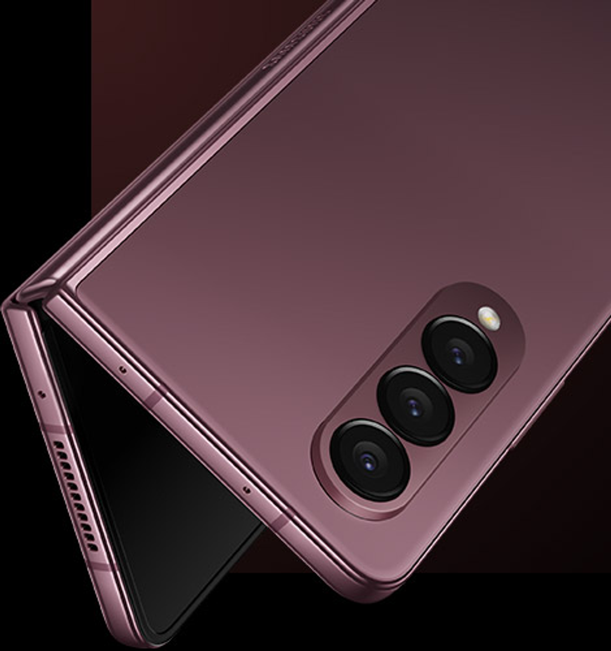 Składany telefon, fioletowy, częściowo otwarty, z potrójnym aparatem. Fioletowa ramka.