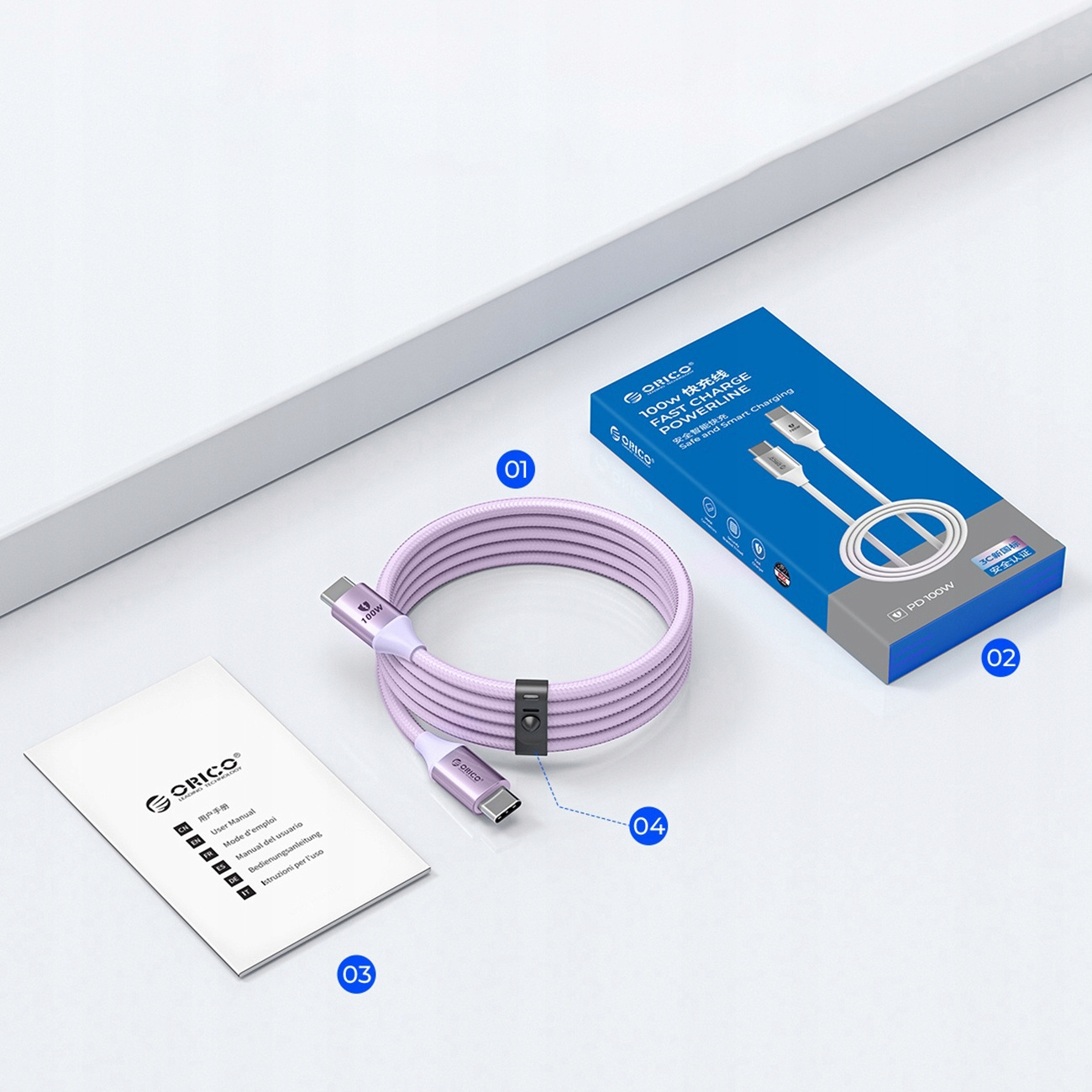 Ein pinkfarbenes USB-C-Kabel, eine Box, ein Handbuch und eine weiße Oberfläche. Box mit 'ORICO'.
