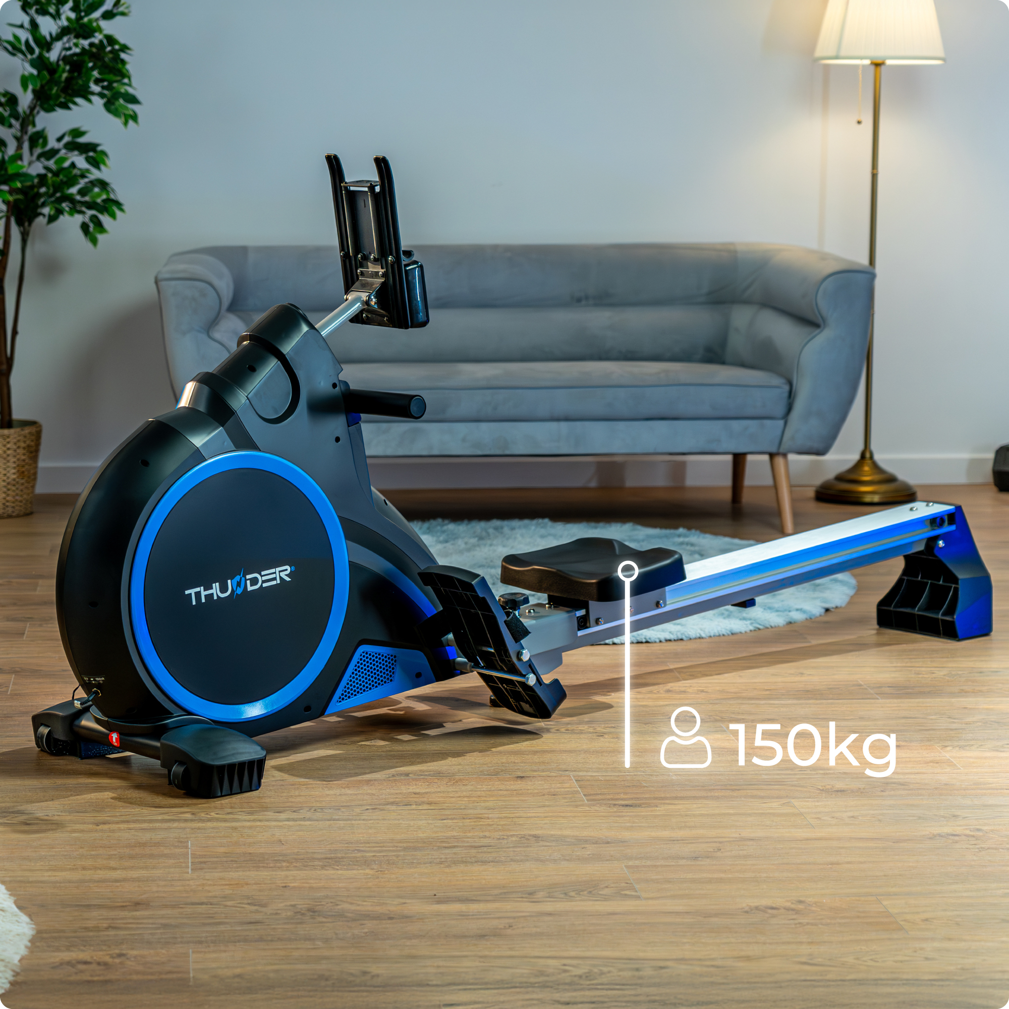 Wioślarz z ikoną limitu wagi 150 kg. Niebiesko-czarny design. Wnętrze pokoju z sofą i lampą.