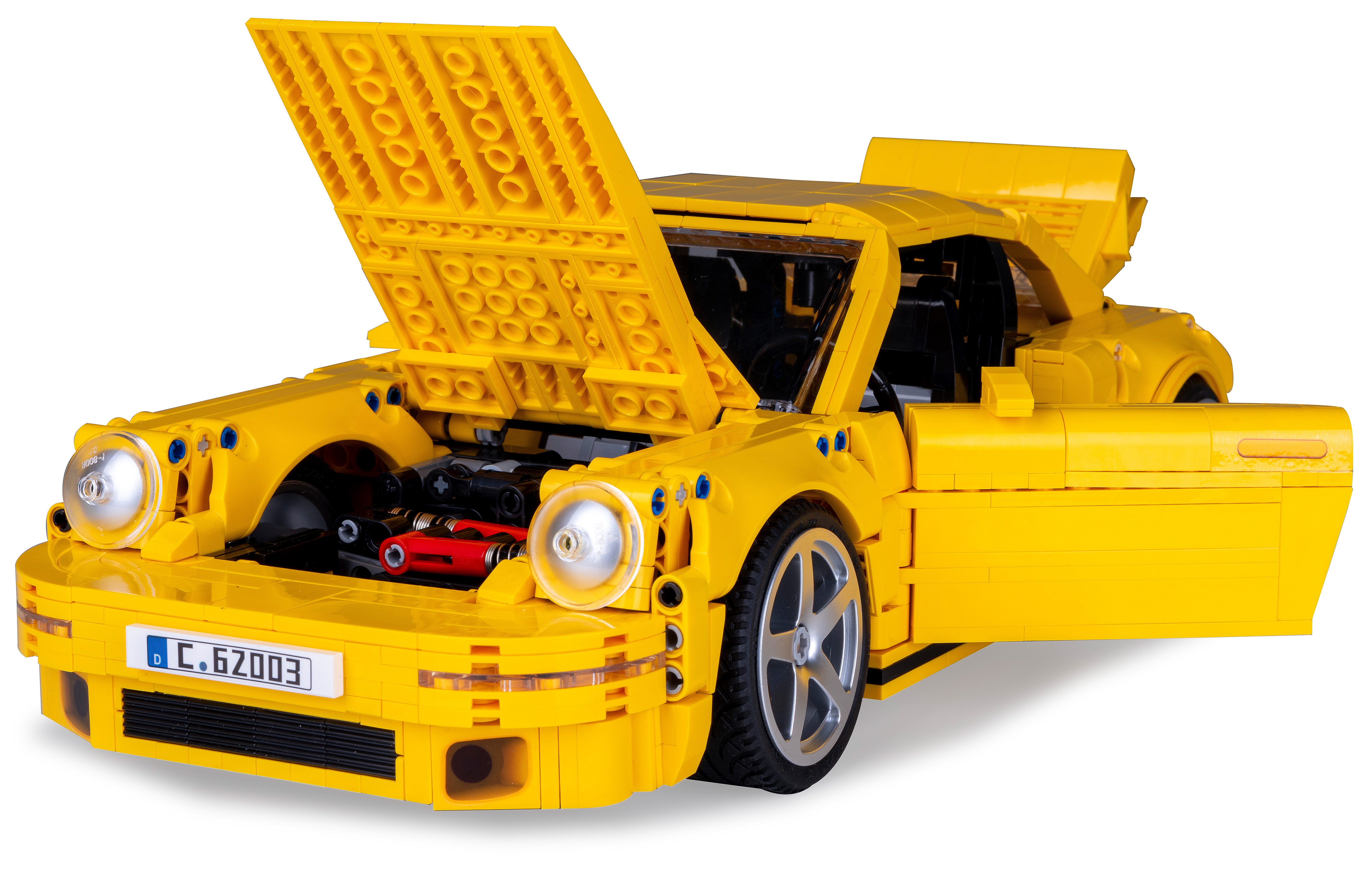 Gelber Lego Porsche mit geöffneter Motorhaube, Türen offen. Schwarzer und roter Motor sichtbar. Weißer Hintergrund.