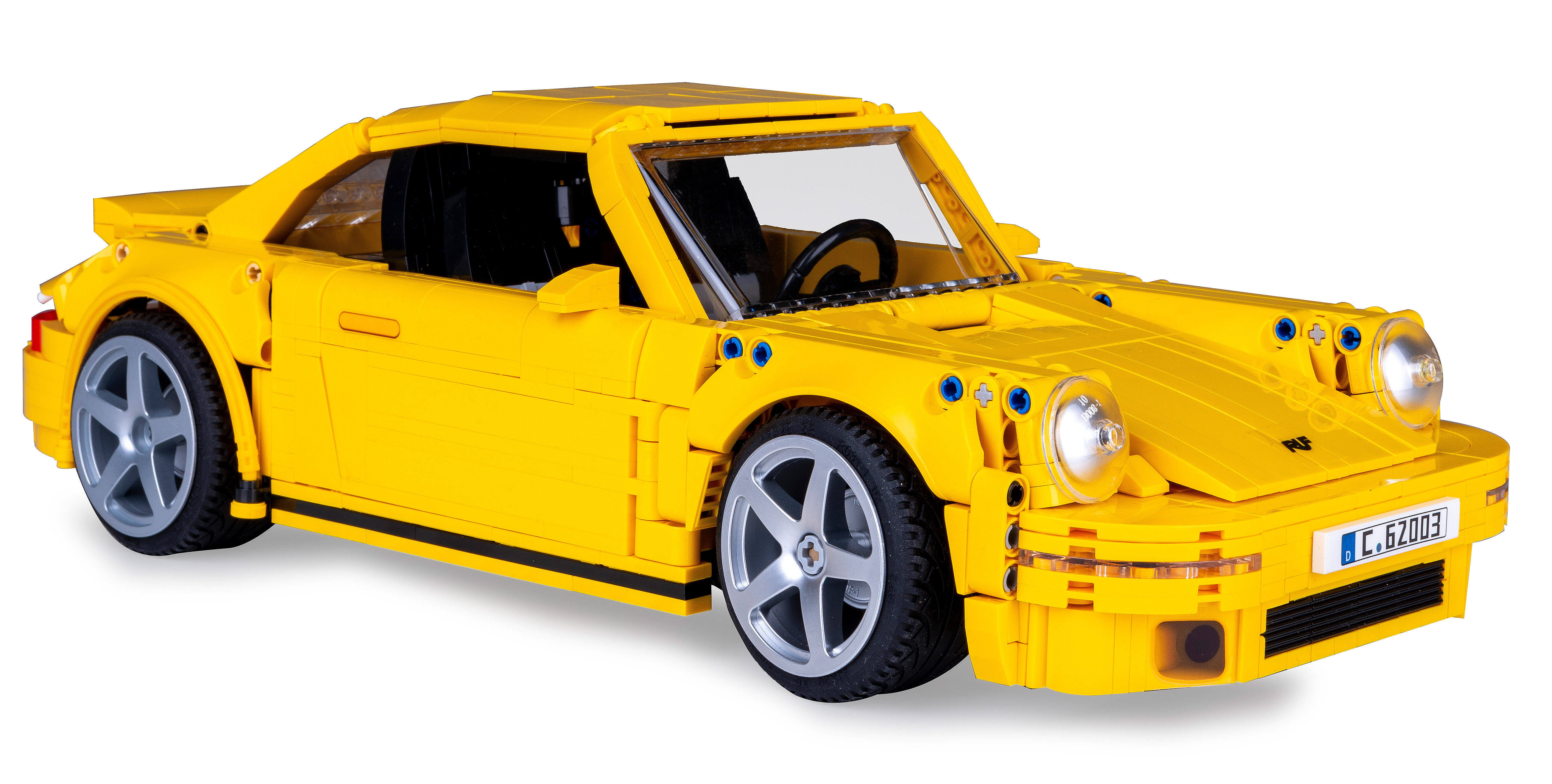 Gelber Lego Porsche. Die Türen sind geschlossen. Weißer Hintergrund.