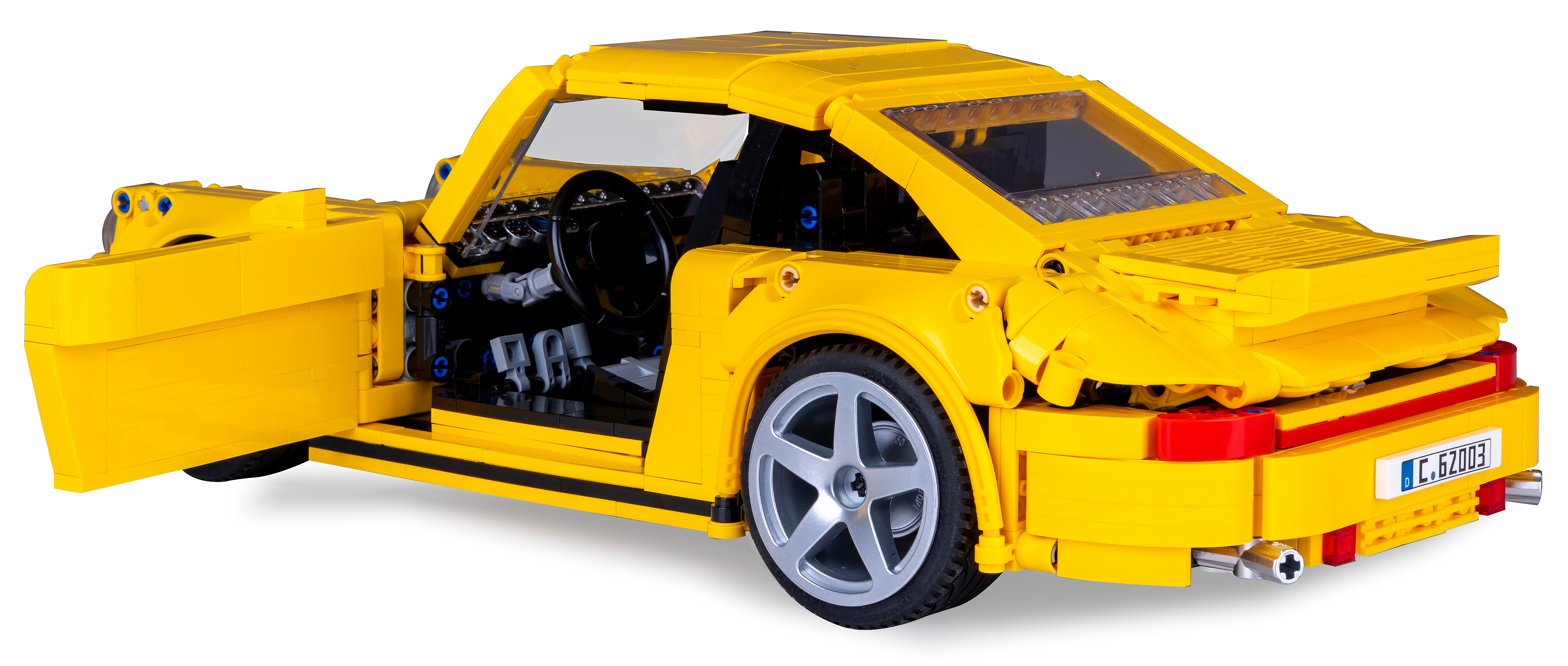 Ein gelbes Spielzeugauto mit offener Tür, von hinten aufgenommen.