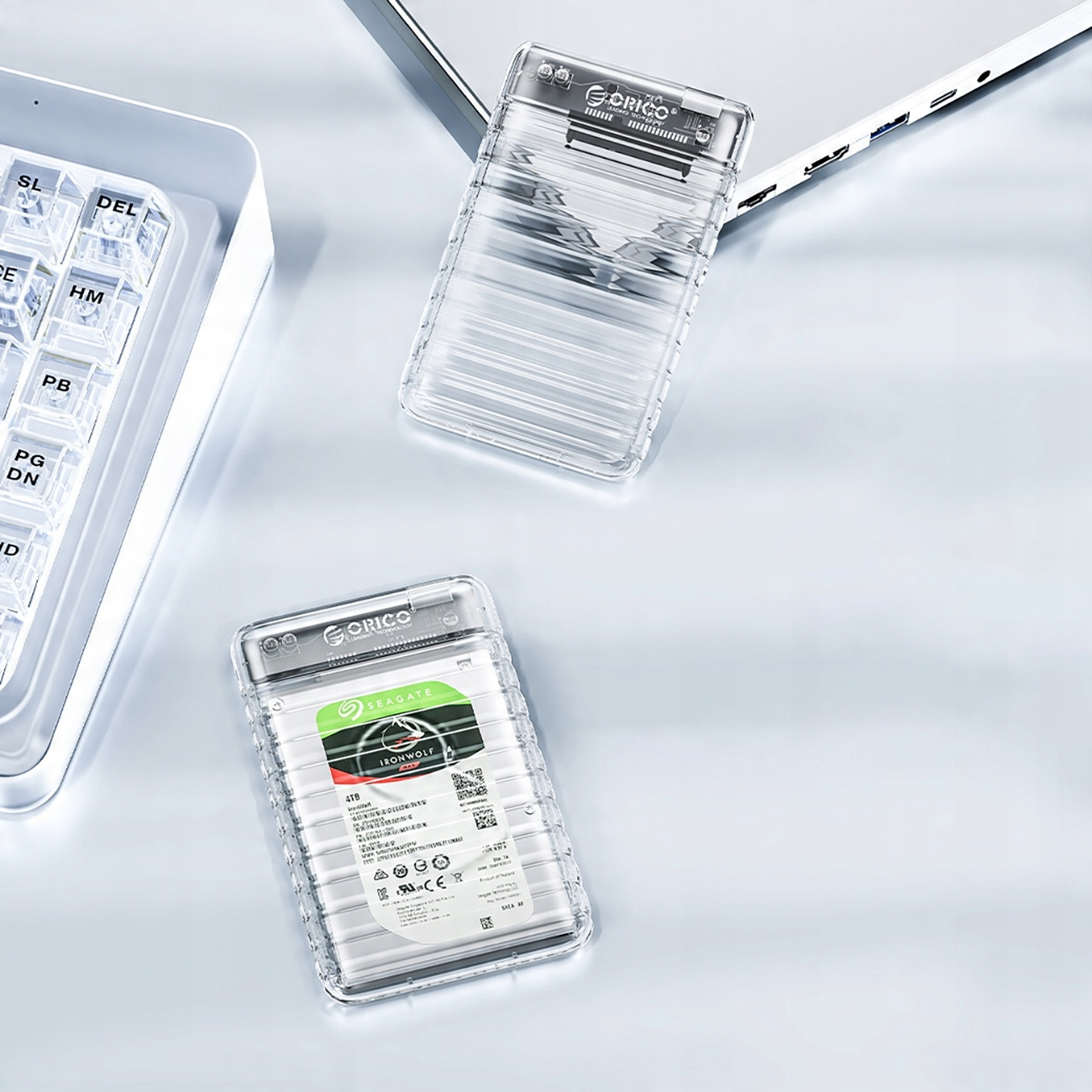 Dwie przezroczyste zewnętrzne obudowy dysków twardych, jedna z dyskiem w środku.