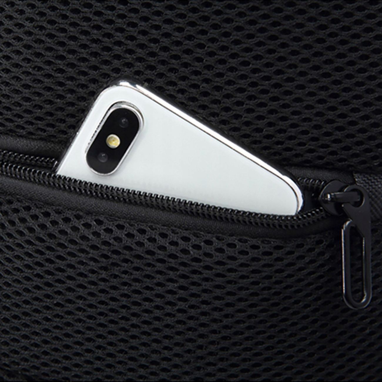 Telefon w kieszeni czarnej torby.