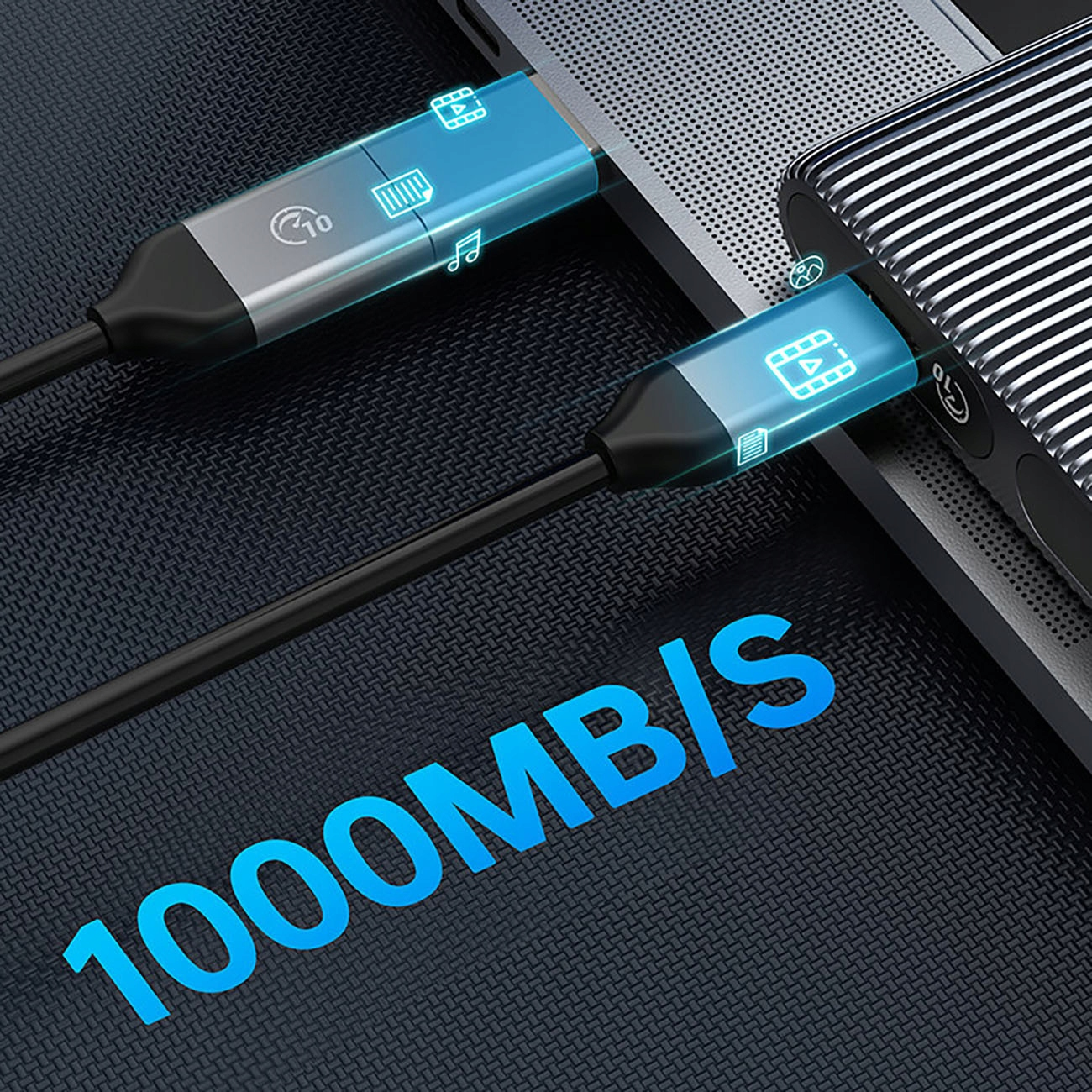 Un cavo USB nero è collegato a un laptop e a un dispositivo argentato. Il testo '1000MB/S' è visibile.